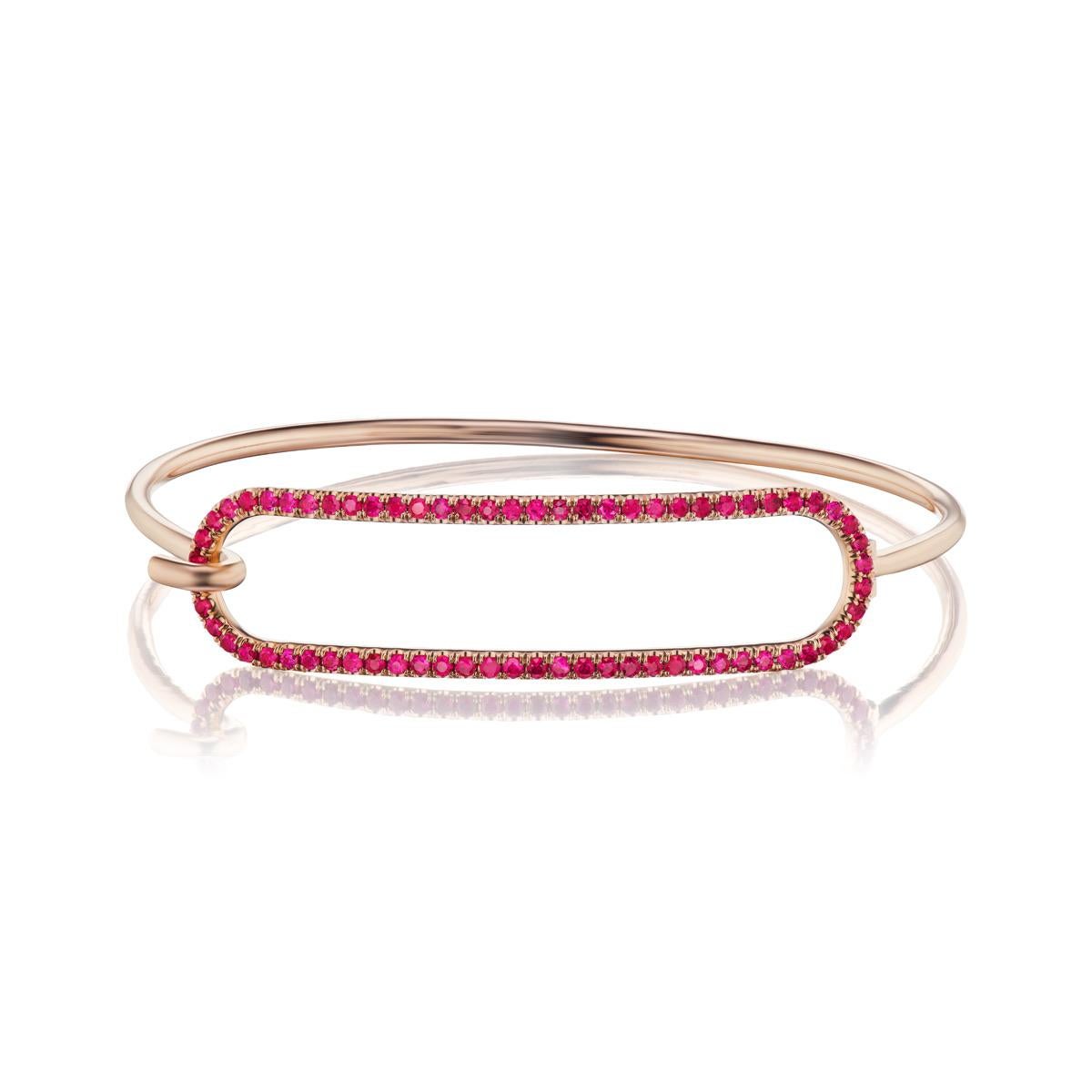 Andrew Glassford's signature 2mm Ruby Tension Bracelet in 18K rose gold with 1.2 carats of round rubies that creates a vibrant pop of color on the wrist. The entire bracelet is made of a 2mm round 18k rose gold wire. The tension series is based off