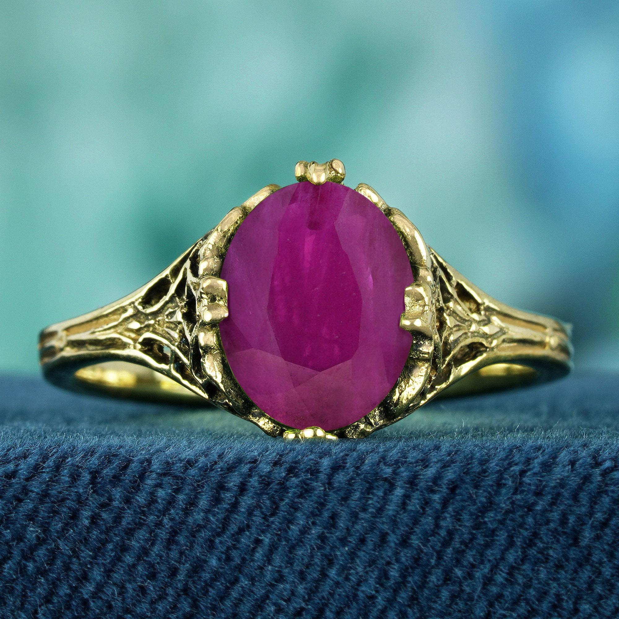 A  La pièce maîtresse est un rubis rouge riche et profond, de forme ovale, serti dans un anneau filigrané aux détails exquis. Le design délicat, d'inspiration vintage, met en valeur la beauté du rubis, lui conférant une allure intemporelle et