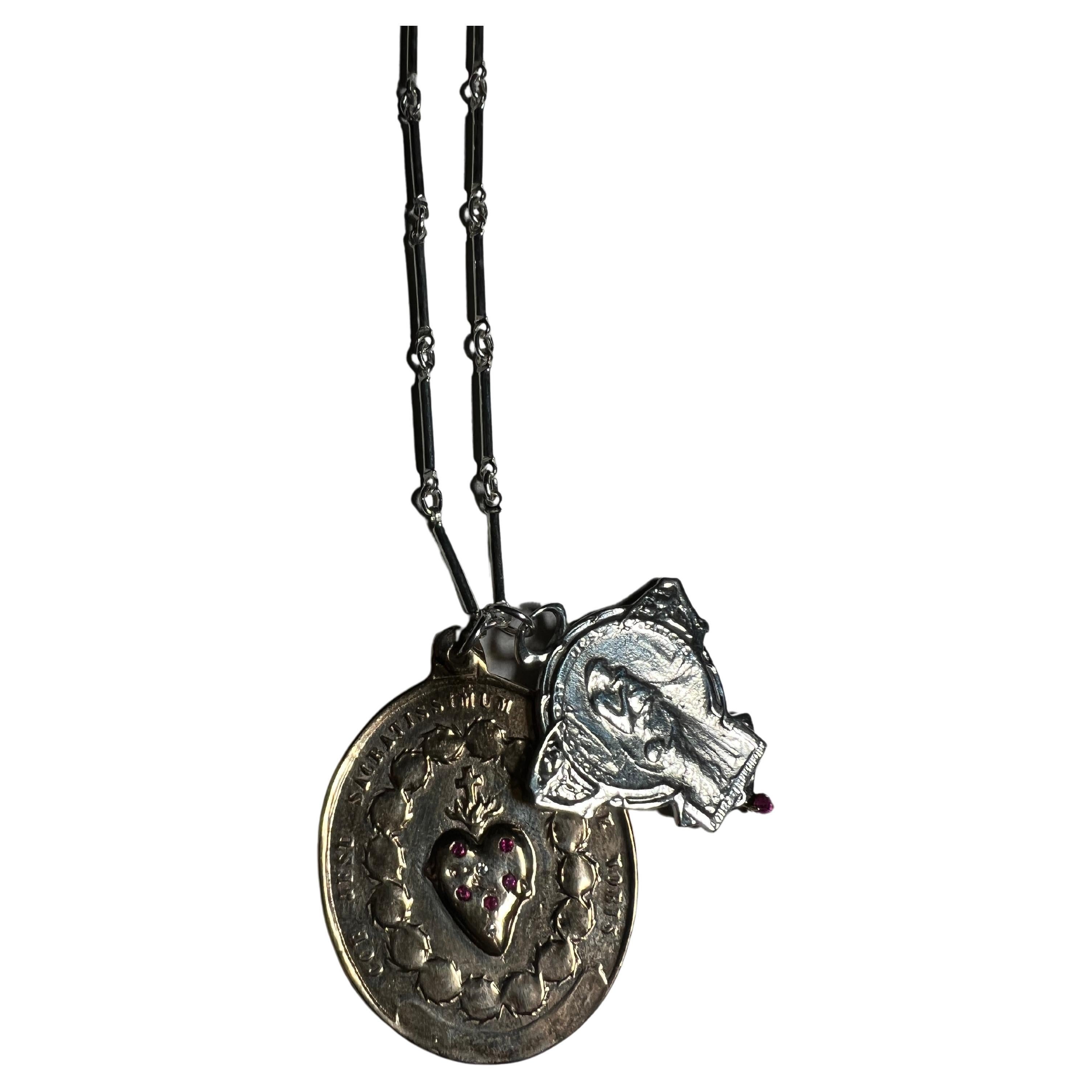 Médaille du Sacré-Cœur en bronze recouverte de rubis et de diamants blancs et médaille Art Nouveau en argent avec un rubis suspendue à une chaîne en argent. 
Taille : 28
