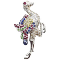 Broche en or blanc 18 carats avec rubis, saphirs jaunes et bleus, tsavorites et autruche