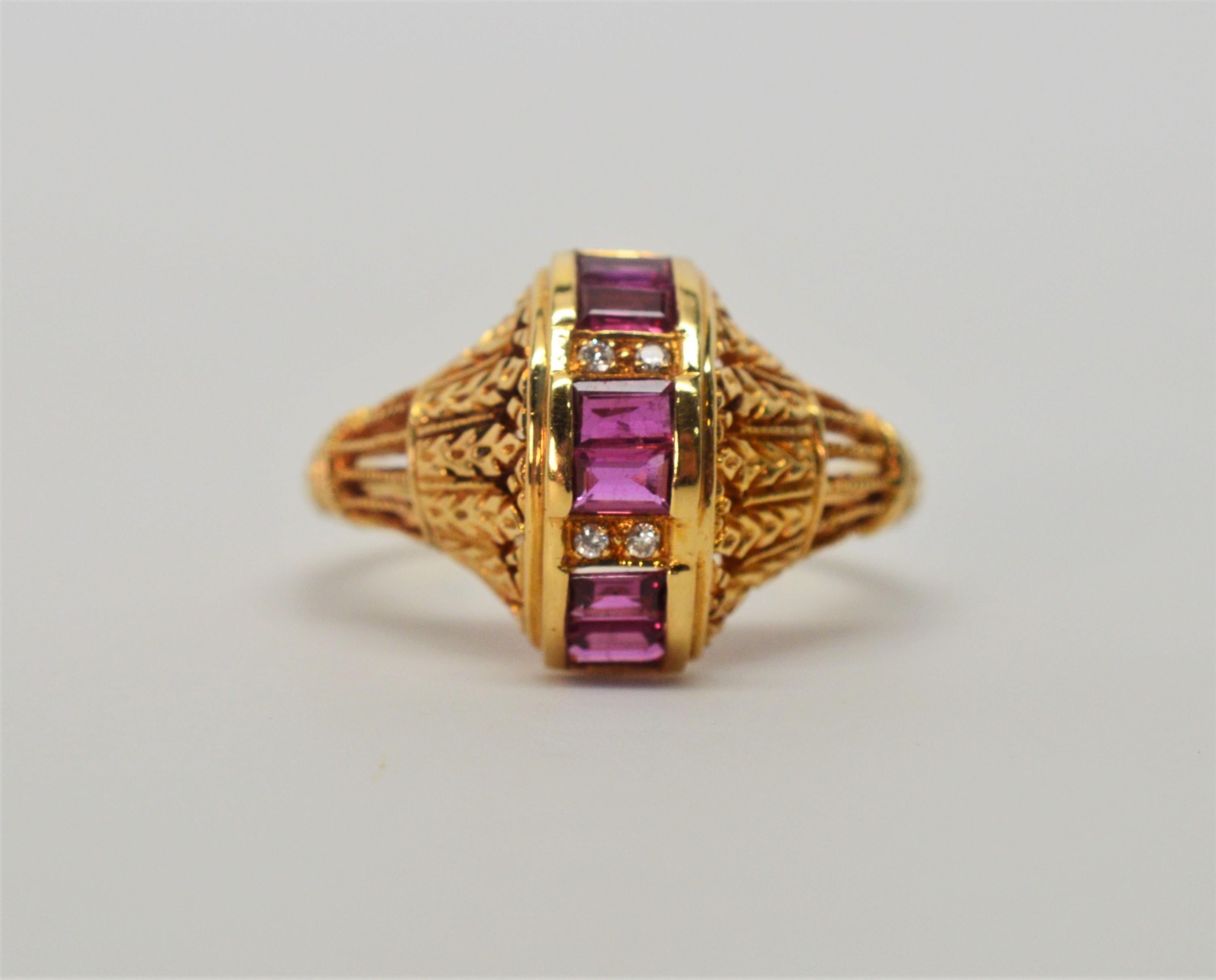 Eighteen carat yellow gold with ornate filigree create this elegant band leading to the ring center generously inset with a vertical band of six gem quality emerald-cut rubies, approximately .30 carats total weight , which are delicately adorned
