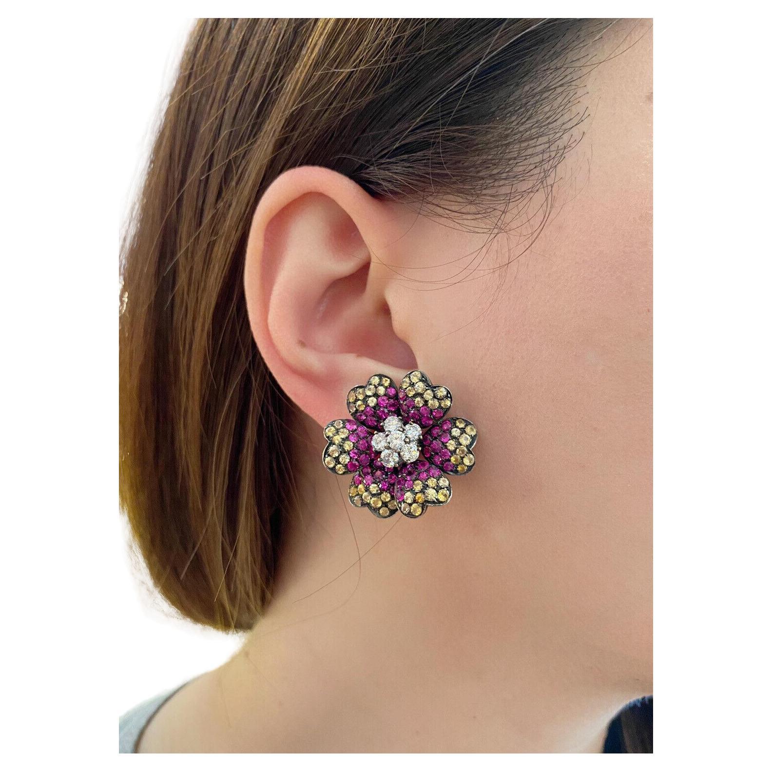 Ruby, Yellow Sapphire and Diamond Flower Earrings in 18k Gold

Ruby, Yellow Sapphire and Diamond Flower Earrings features 6 Round Brilliant Diamonds in the center with Rubies and Yellow Sapphires on the petals set in 18k White Gold in Black Rhodium.