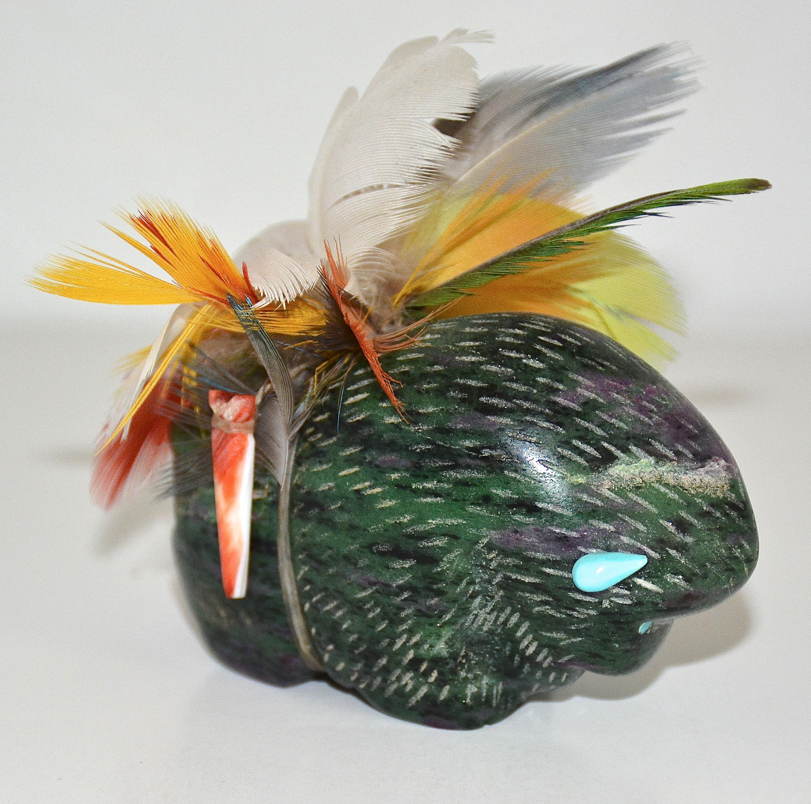 Fetiche de búfalo envuelto en plumas
Rubí Zoisita, turquesa, ostra espinosa, plumas, tendones.
Amos Pino
2002
3 pulgadas de alto x 3 pulgadas de largo x 1,5 pulgadas de ancho.

Este búfalo fue tallado en zoisita rubí con cuernos y ojos de turquesa,