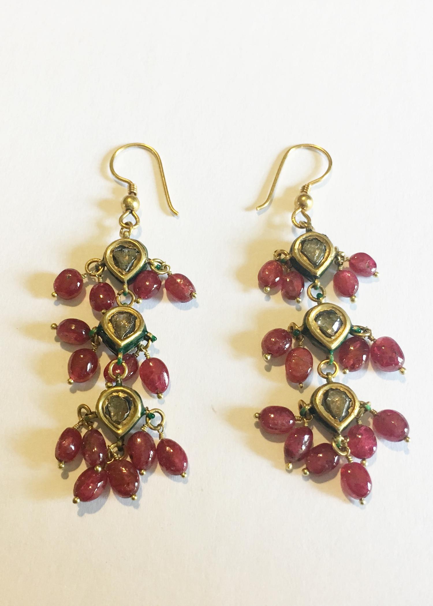A magnificent pair of Kundan chandelier earrings with polished rubies and flat-cut, foil-backed diamonds set in 18 karat gold with green enamel. These Rajasthani earrings were handmade using the traditional Kundan process, which involves setting