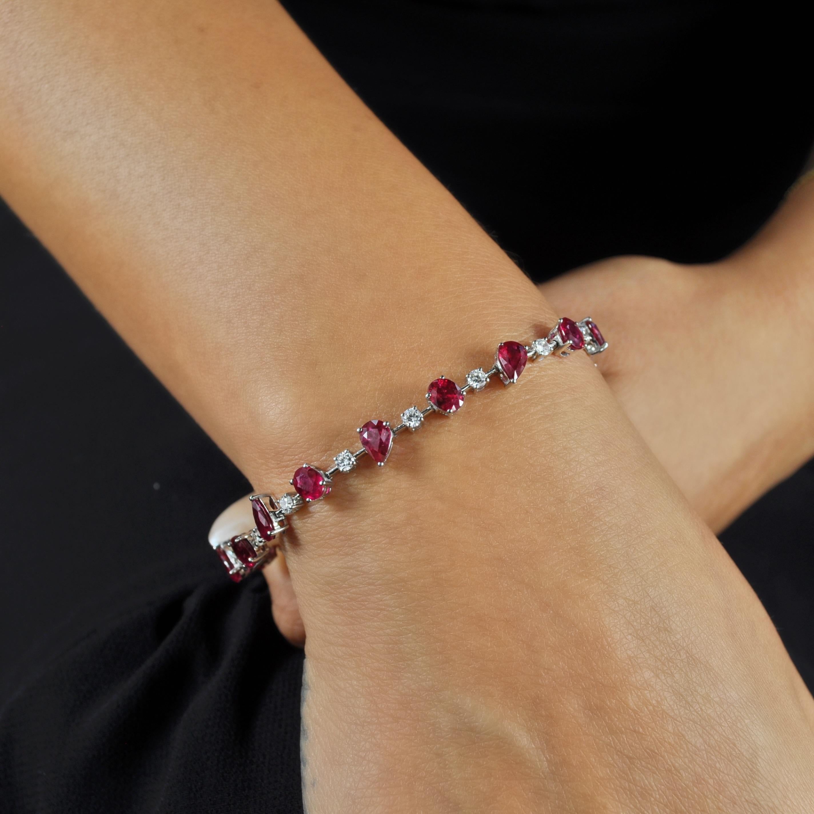 Dieses Armband aus 18 Karat Weißgold zeigt Rubine in verschiedenen Formen, die durch Diamanten im Brillantschliff getrennt sind. Sie enthält einen Kastenverschluss mit zwei Achter-Sicherheitsverschlüssen. Das Armband kann allein als dezenter Akzent