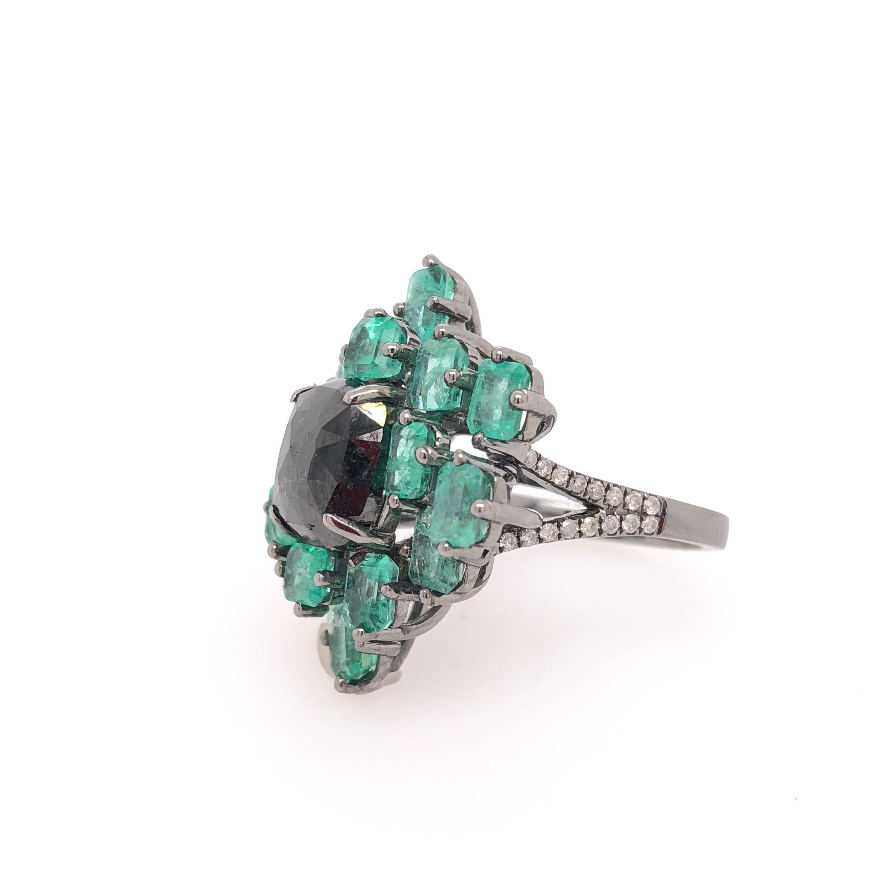 Green Lagoon Collection

 Black Diamond center stone ring with Emeralds surrounding set in 18K black rhodium gold. 

Emerald: 3.90ct total weight.
Diamonds: 0.20ct total weight.
All diamonds are G-H/SI stones.
Height - is approximately