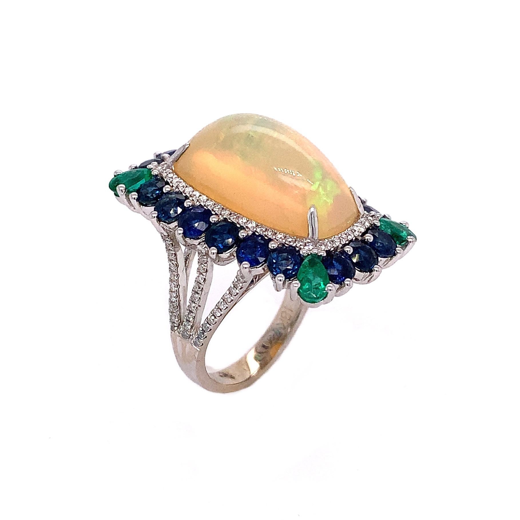 This beautiful opal ring features an Ethiopian opal with emerald and blue sapphire accents set in 18K white gold. 