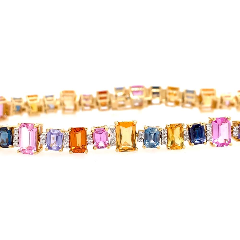 Play of Colors Collection

Emerald cut multicolor Sapphire tennis style bracelet set in 18K yellow gold.

Multicolor Sapphire: 14.23ct total weight.
Diamonds: 0.40ct total weight.
All diamonds are G-H/SI stones.