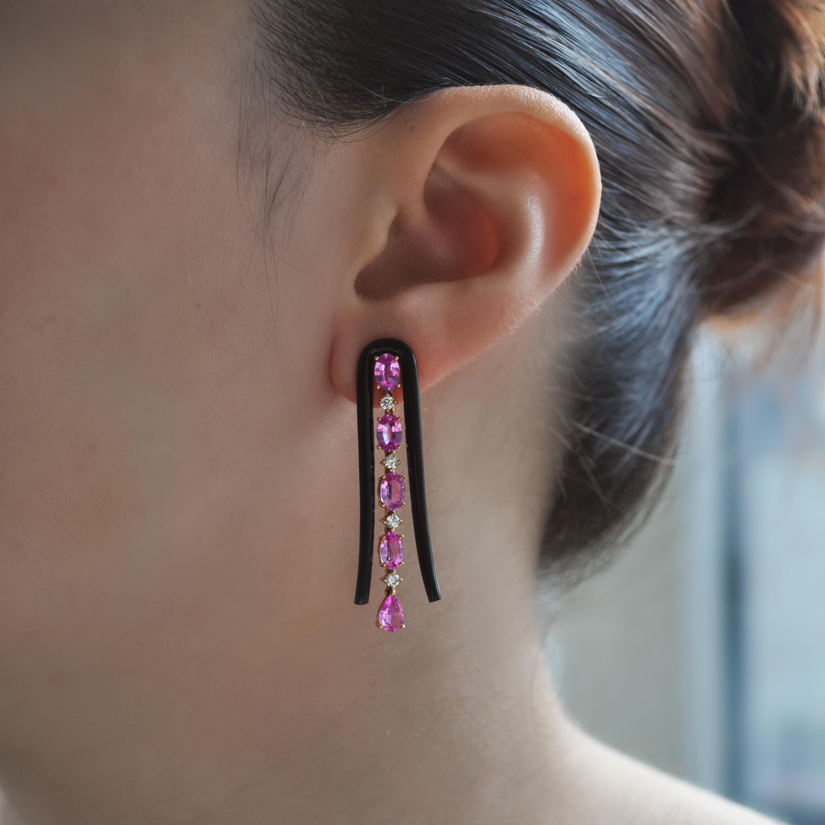 This U-shaped dangle earring features a line of pink sapphires and diamond accents with a black agate arch, set in 18k rose gold.

18k Rose Gold
Pink Sapphire - 4.30 Ct
Agate - 3.63 Ct
D- 0.33 Ct

All Diamonds are G-H/SI
