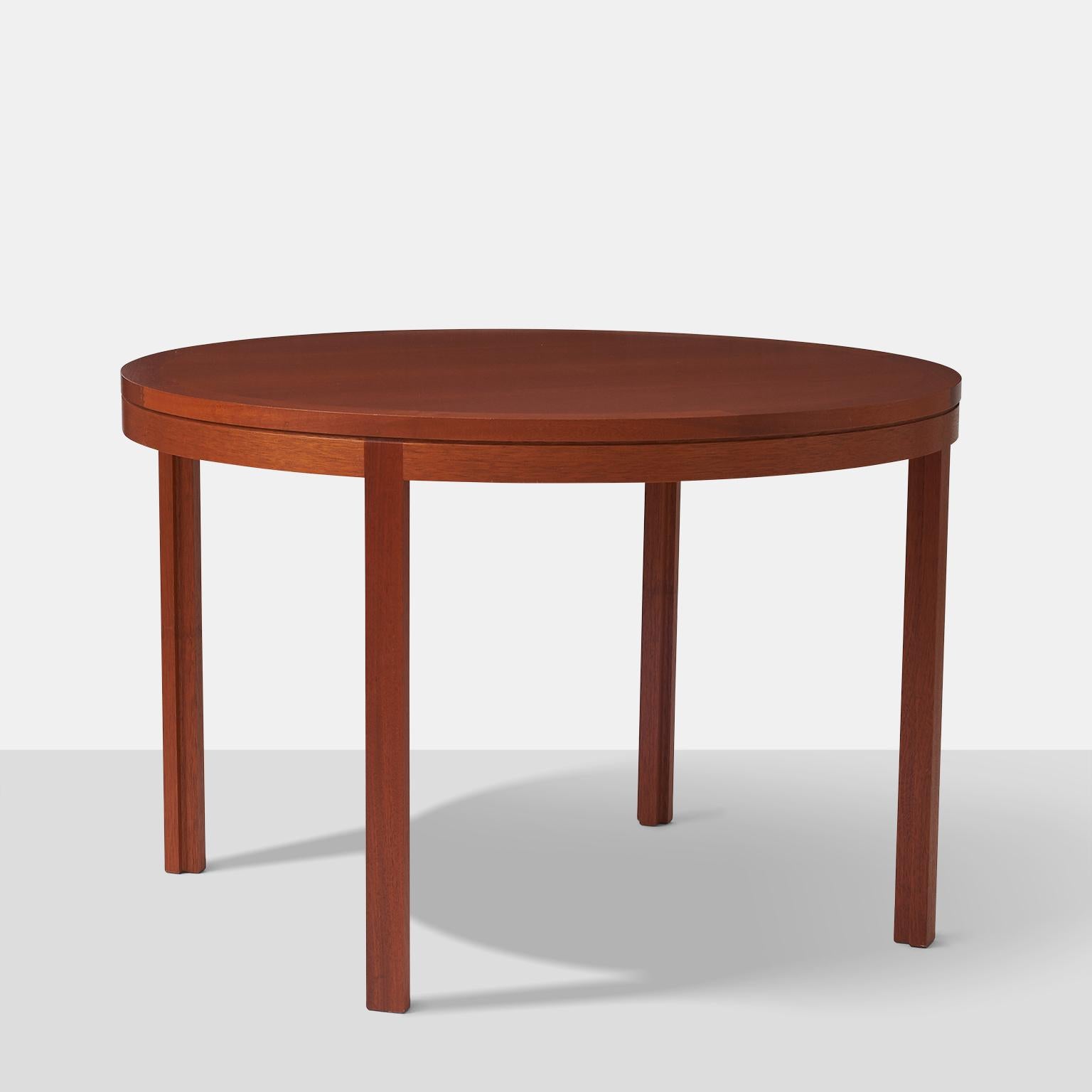 A round mahogany dining table with parson's legs. Manufactured by Botium.