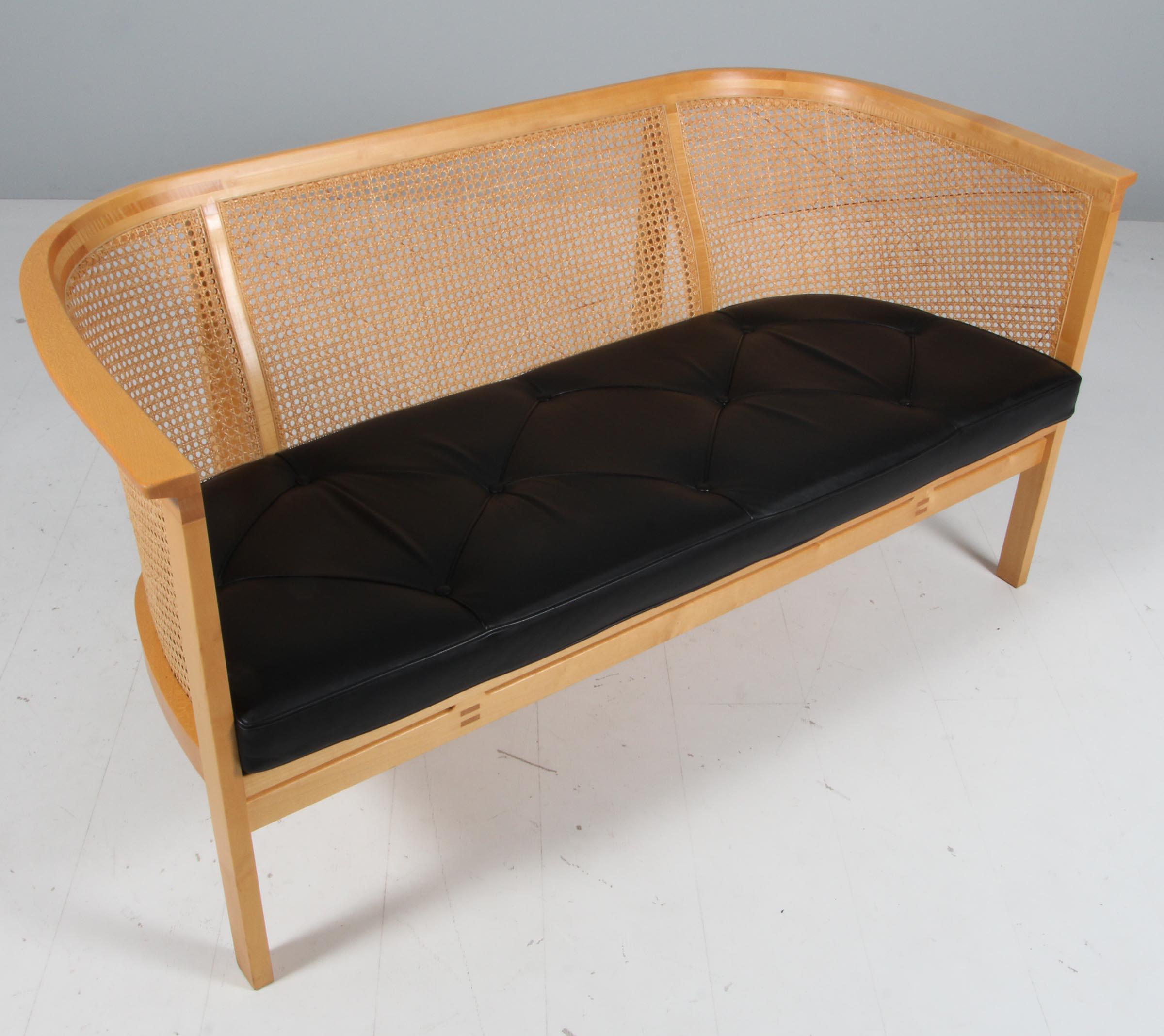 Rud Thygesen & Johnny Sørensen two seat sofa with frame of elm.

Cane in the back, original patinated black leather seat cushions.

From 