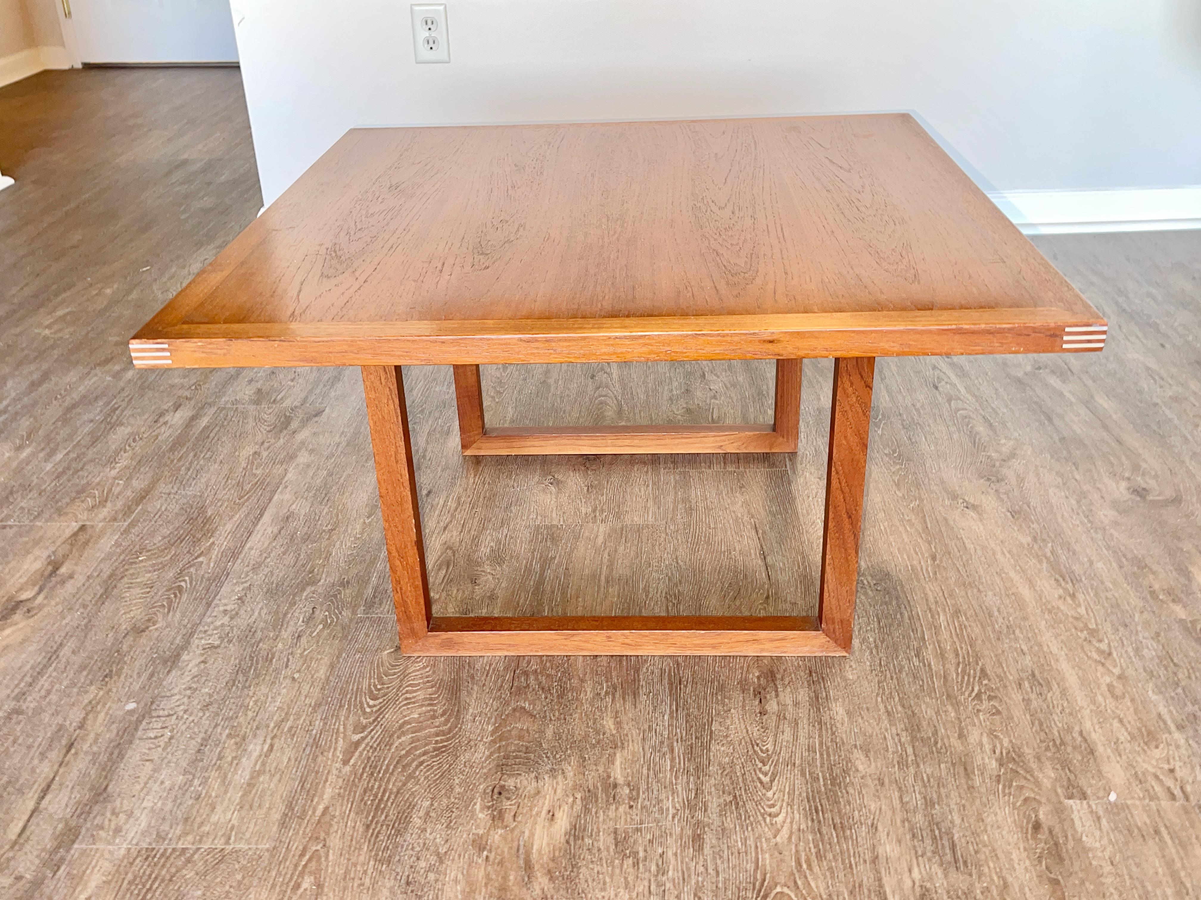 Teak coffee or side table designed by Rud Thygesen for Heltborg Møbler, Denmark. 
The rich teak contrasts beautifully with the aluminum inlays at the corners and on the base.
23.5 wide x 23.5 deep x 18 inches high.
Label present on underside.