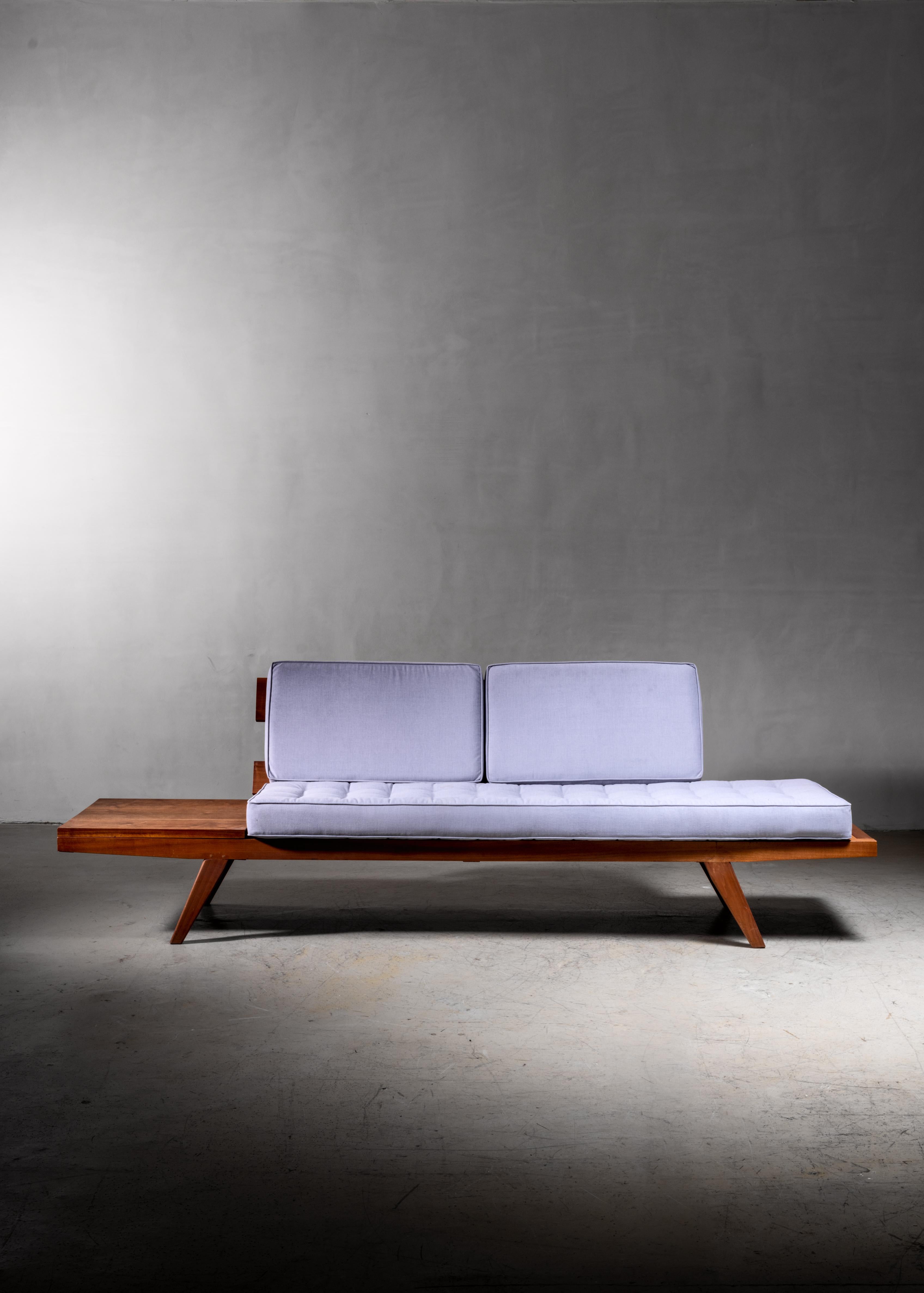 A studio crafted sofa by American woodworker Rude Osolnik. The sofa is made of wood with three custom-made cushions with a blue fabric upholstery.

Osolnik (1915-2001) was one of the most important post-war American craftsmen. The Queen of England