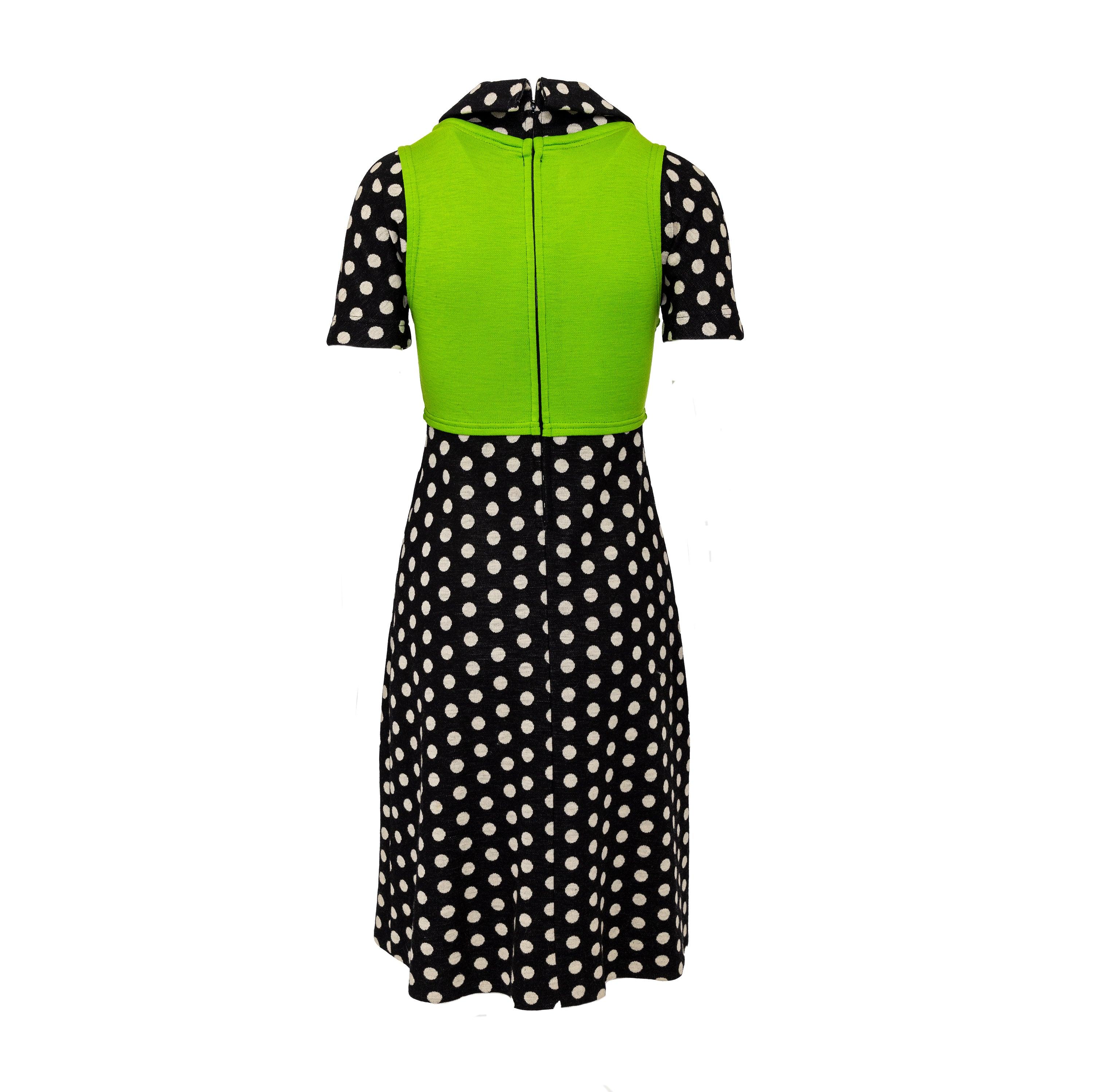 Dieses Midikleid aus Wolle erinnert an den kühnen und innovativen Stil der 60er Jahre. Dieses vom avantgardistischen Modedesigner Rudi Gernreich entworfene Kleid zeichnet sich durch ein tailliertes Mieder und eine kontrastierende Weste aus. Der