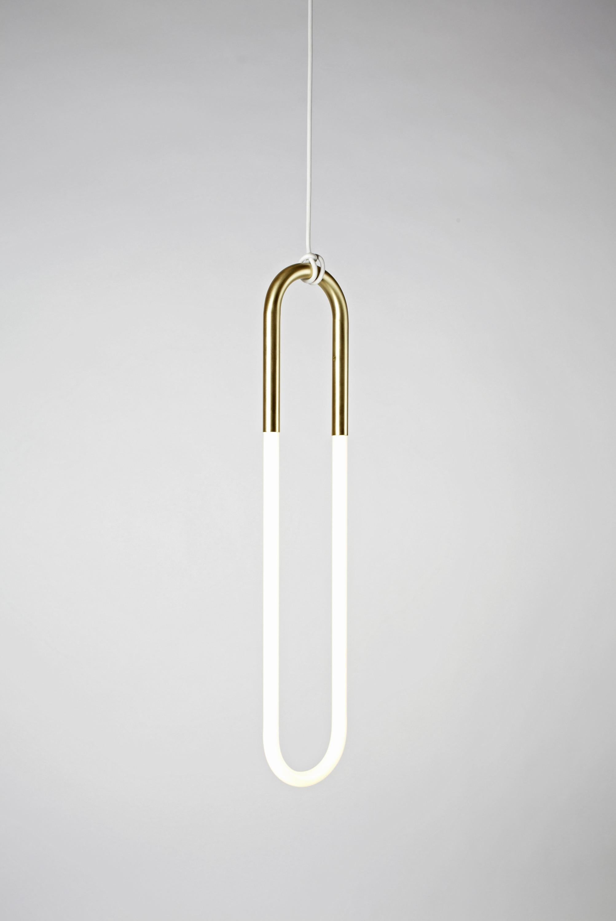 Jewelry is the inspiration for Rudi, a series of pendant lamps named after designer Lukas Peet's father, a jeweler. Rudi is made from bent metal tubes that hold handmade cold cathode lamps, with a satin brass finish. The fixtures hang from their