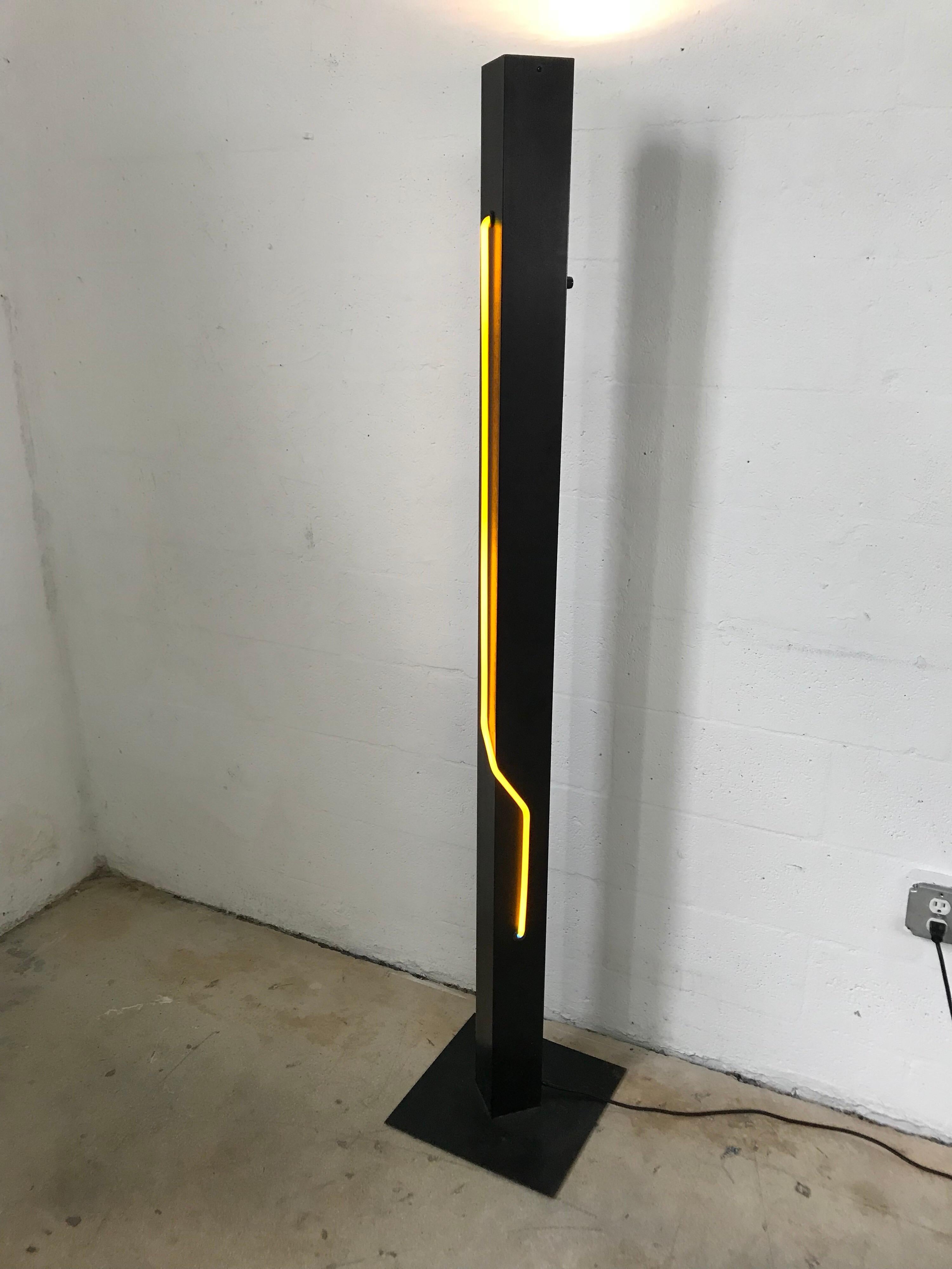 Postmodern floor lamp or torchiere rendered in black powder coated steel with yellow sculptural neon light and a white up-light, both lights can be used together or separately and the up-light has a dimmer, designed by Rudi Stern for George Kovacs.