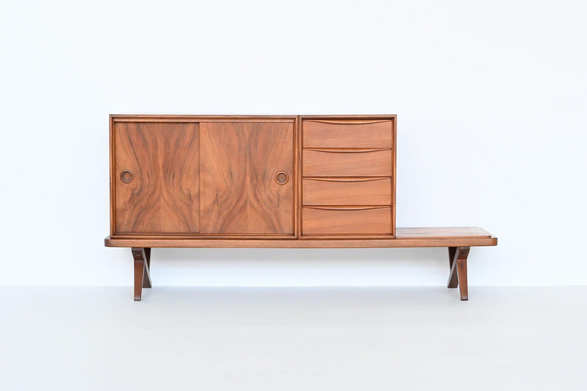 Beautiful shaped sideboard designed by Rudolf Bernd Glatzel and manufactured by Fristho Franeker, The Netherlands 1955. This nice sideboard has two compartments; one with sliding doors and a shelve behind and one with four drawers. There is also a