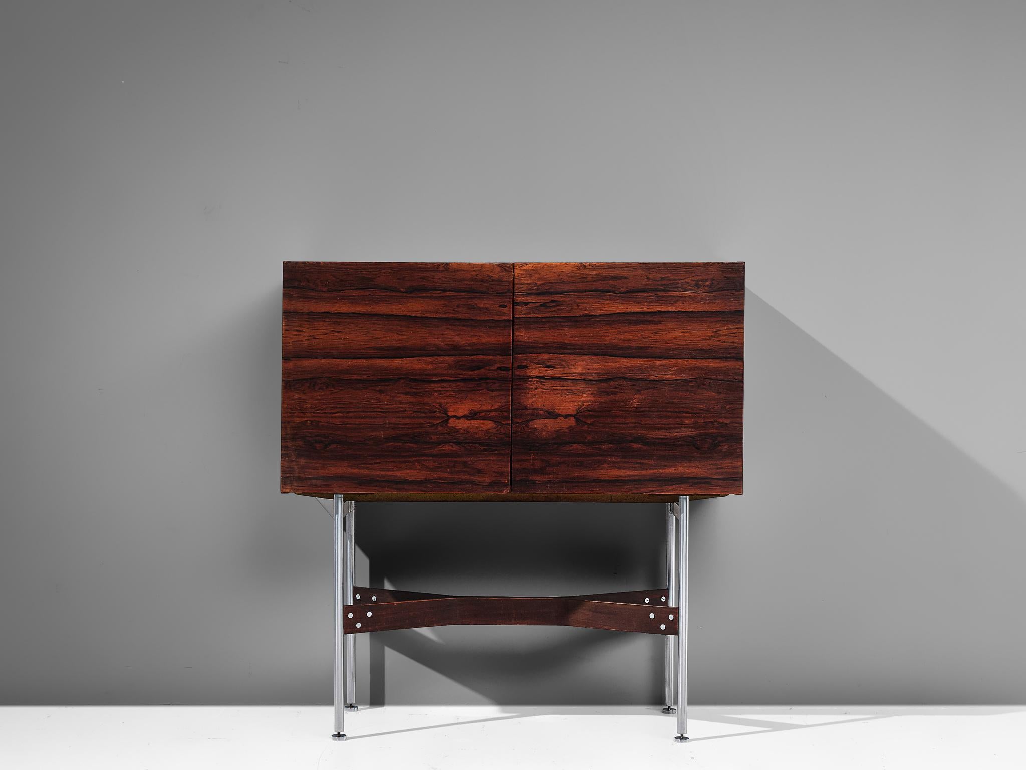 Bar cabinet in rosewood and metal, by Rudolf Bernd Glatzel for Fristho Holland, the Netherlands, 1955.

Well crafted bar cabinet with beautiful proportions. The elegant brushed metal and rosewood base contribute to the floating effect of the two