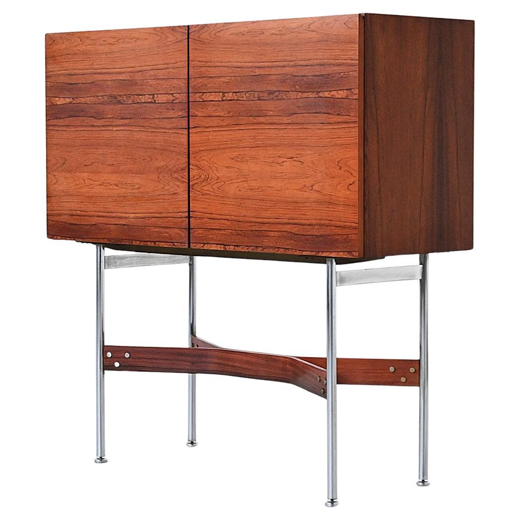 Striking and sculptural, this bar cabinet was designed by Rudolf Bernd Glatzel for Fristho Franeker in the Netherlands in 1956. A hallmark of Glatzel’s refined aesthetic, the cabinet features a richly grained rosewood veneer with beautifully matched