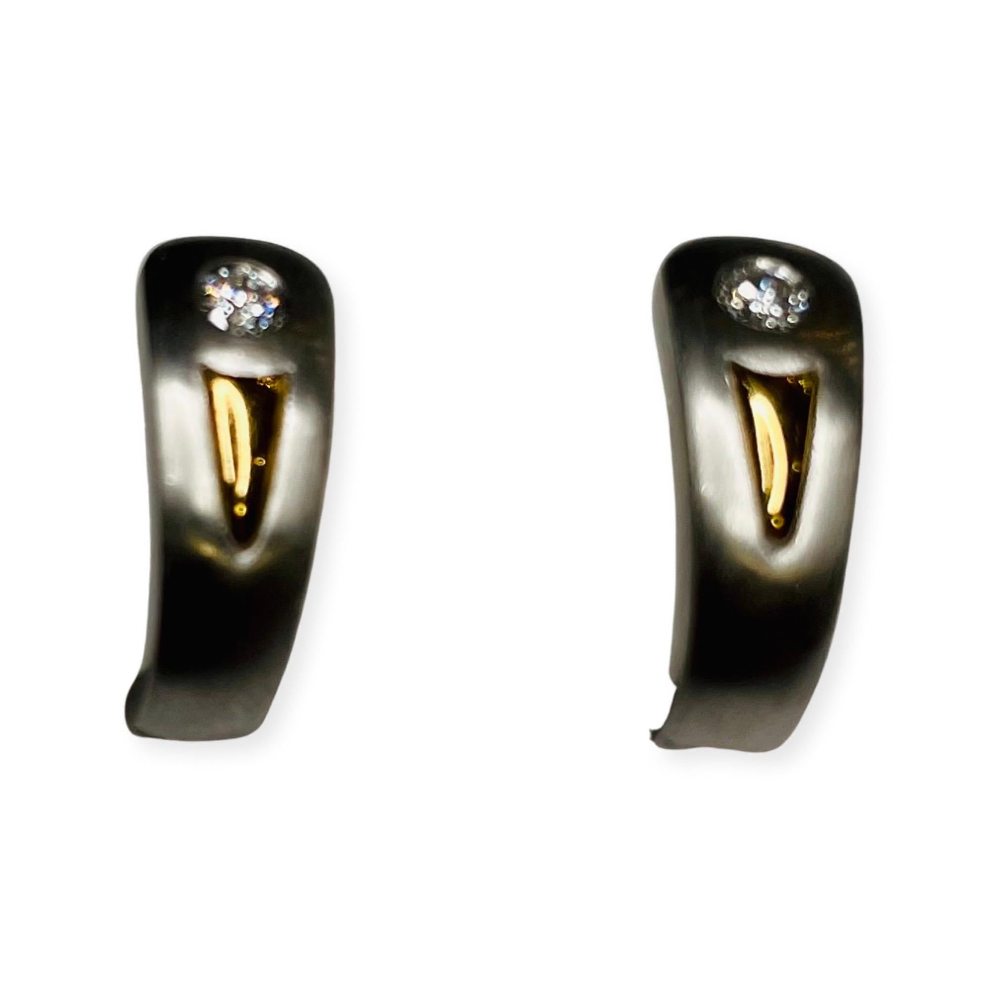 Rudolf Erdel Platinum and 18K Yellow Gold Diamond Earrings.  These are huggie style. The earrings are 15.54 mm by 6.28 mm. The two diamonds have a total weight of 0.16 carats. They are full cut round brilliant diamond of VS clarity and G color. They