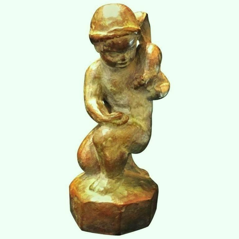Signed by the artist on the plinth, this desk-size sculpture of a child feeding a squirrel was created by the sculptor mostly known for his depictions of children, Rudolph Henn. In this small sculpture, the artist uses an unusual idea of combining