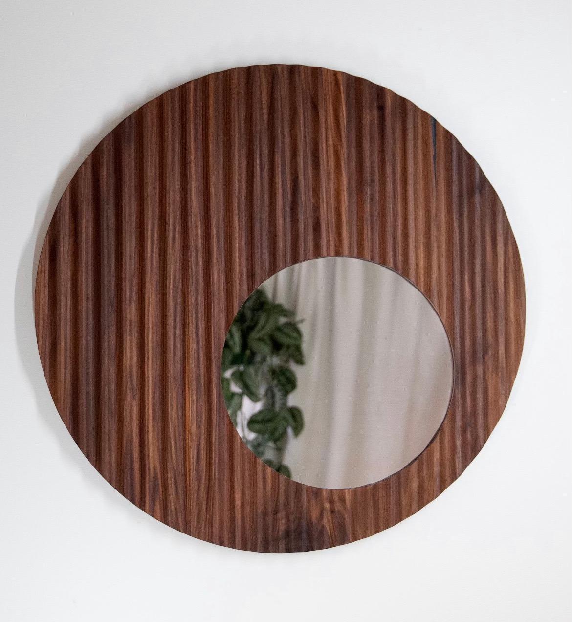 The Ruffle Mirror is designed by North Carolina  craftsman Travis Hyatt. This mirror can work seamlessly with any style interior. It captures light and shadows beautifully as it highlights the natural wood grain. It explores several layers of depth