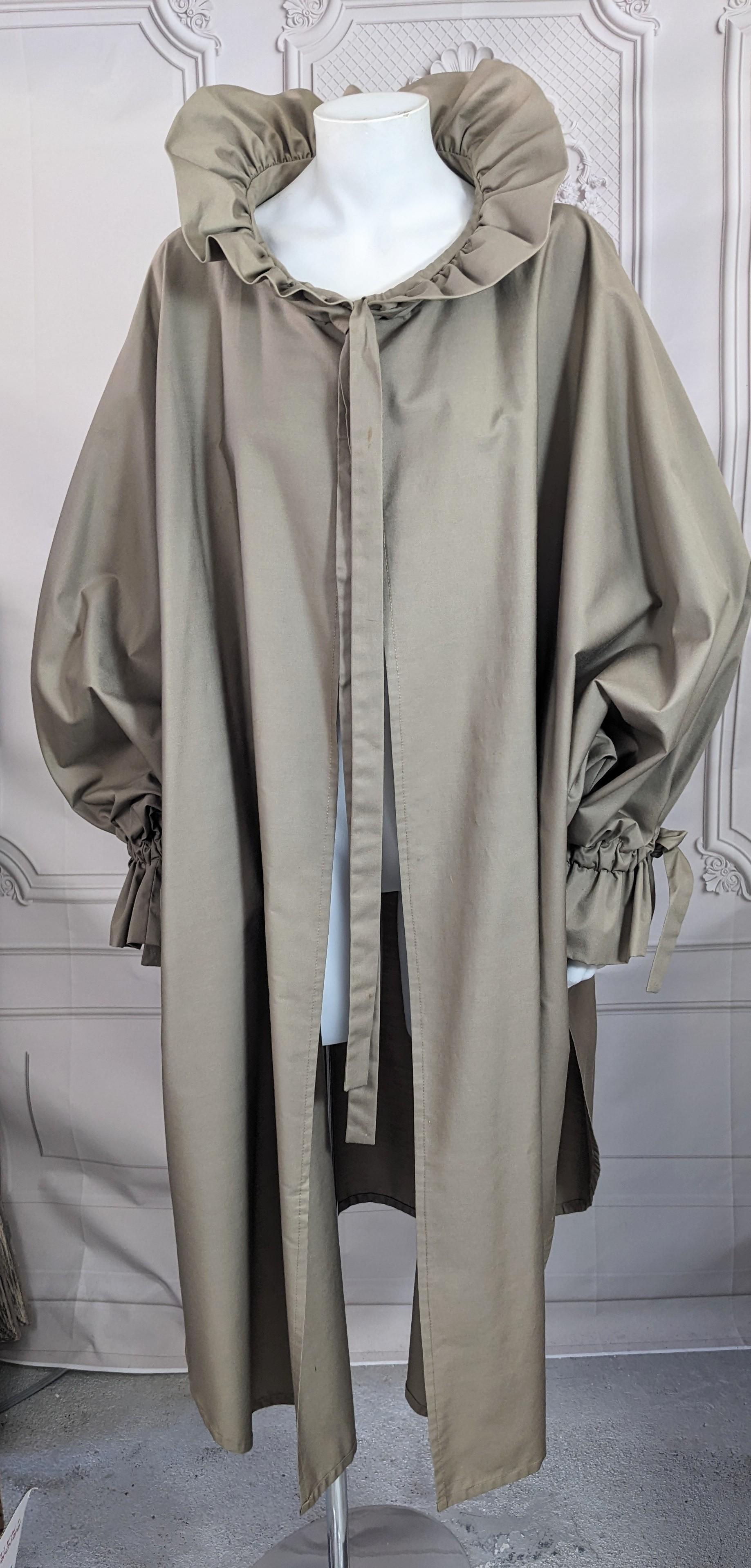 Ruffled Rain Poplin Poncho from the 1980's.  Kimono cut poncho with gathered cuffs and ruffled collar. Ties on front with no other closures. Deep khaki cotton blend poplin. Fits many sizes. 1980's USA. Dry Clean Only. 