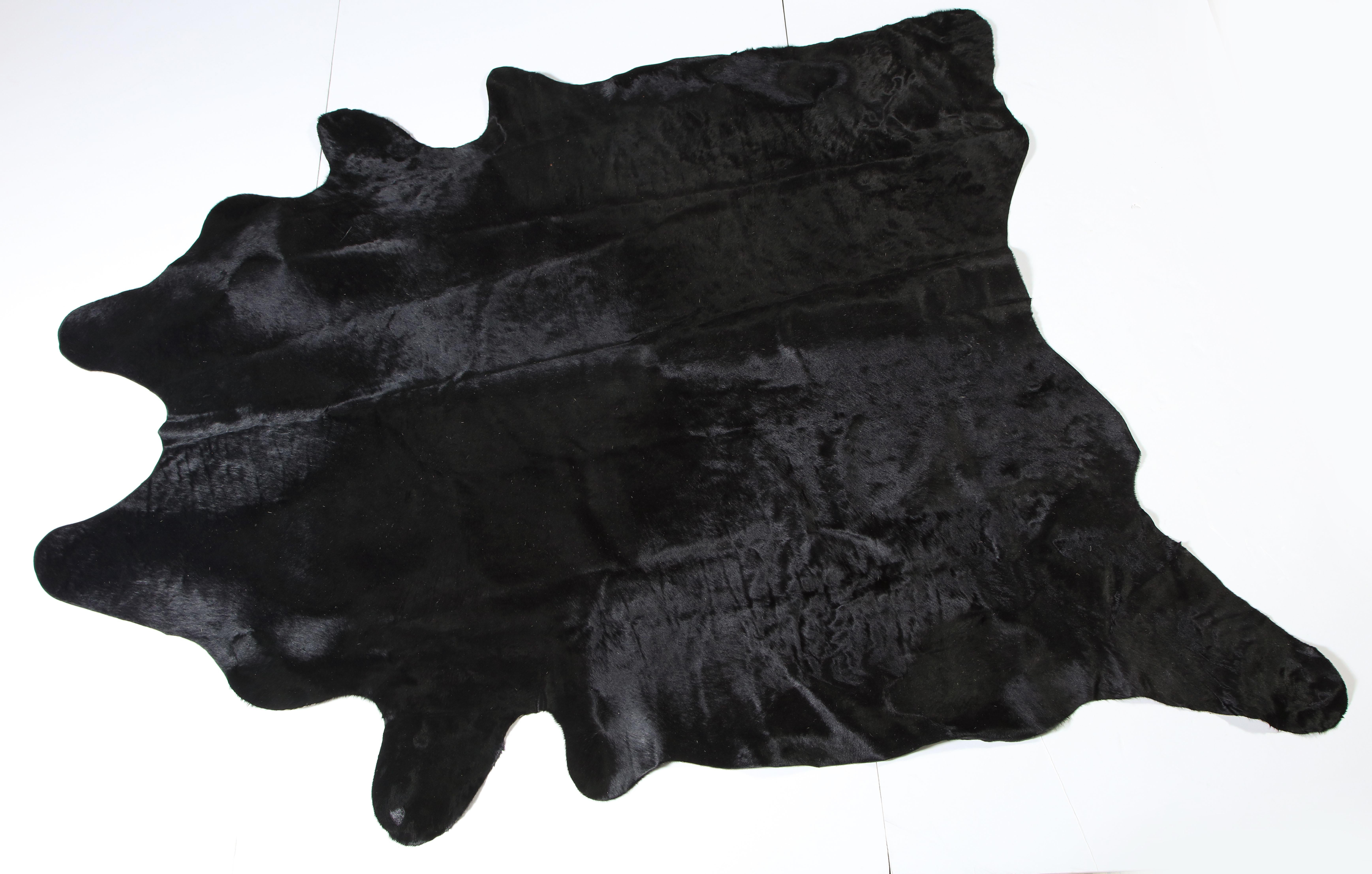 Cow hide, jet black. Lightly used. 
If you measure from each leg, one direction is 110 inches and the other direction is 109 inches.