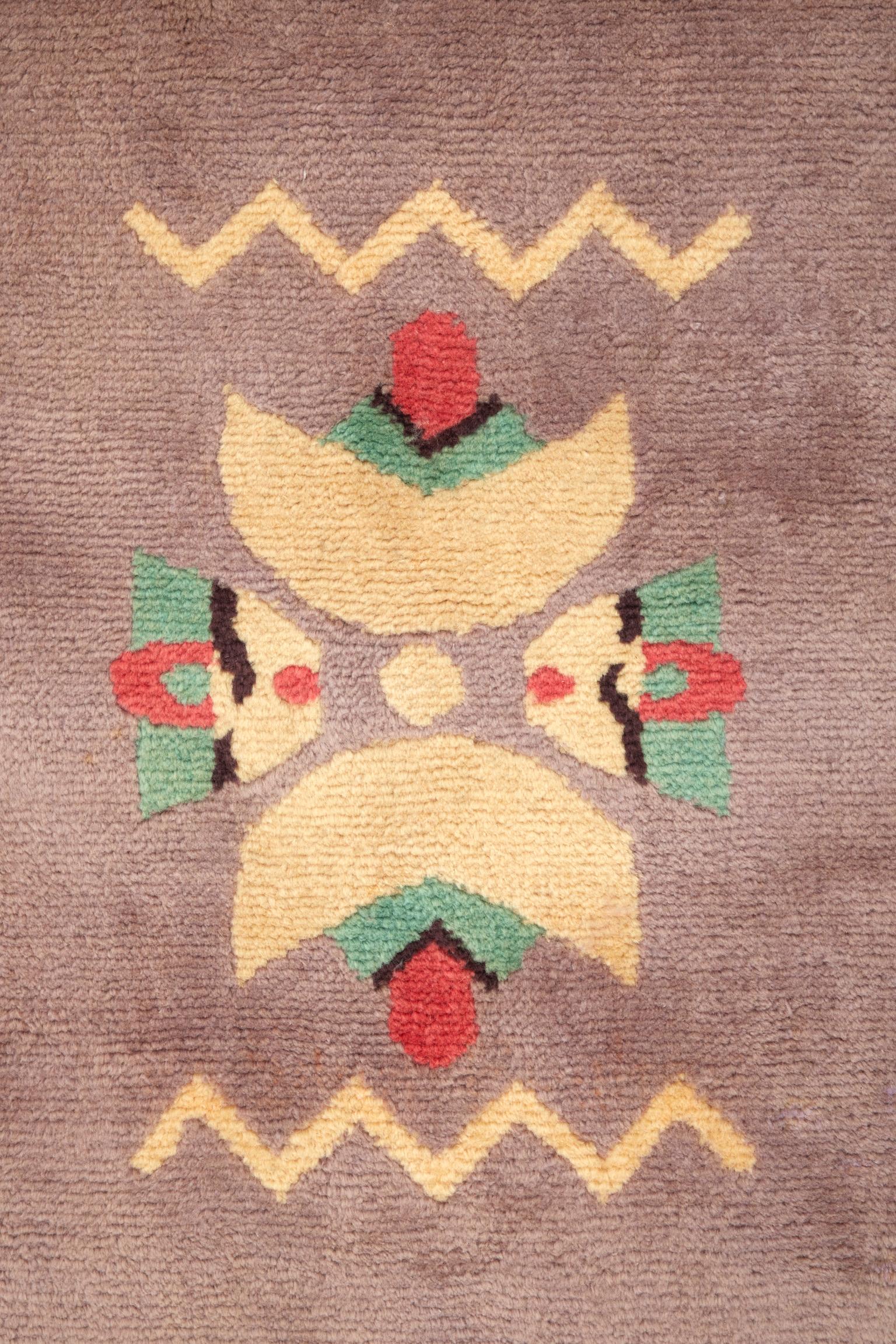 Signed 'Da Silva Bruhns'.
Knotted-stitch wool rug with geometric motifs in shades of mauve, gray, coral, black and yellow.