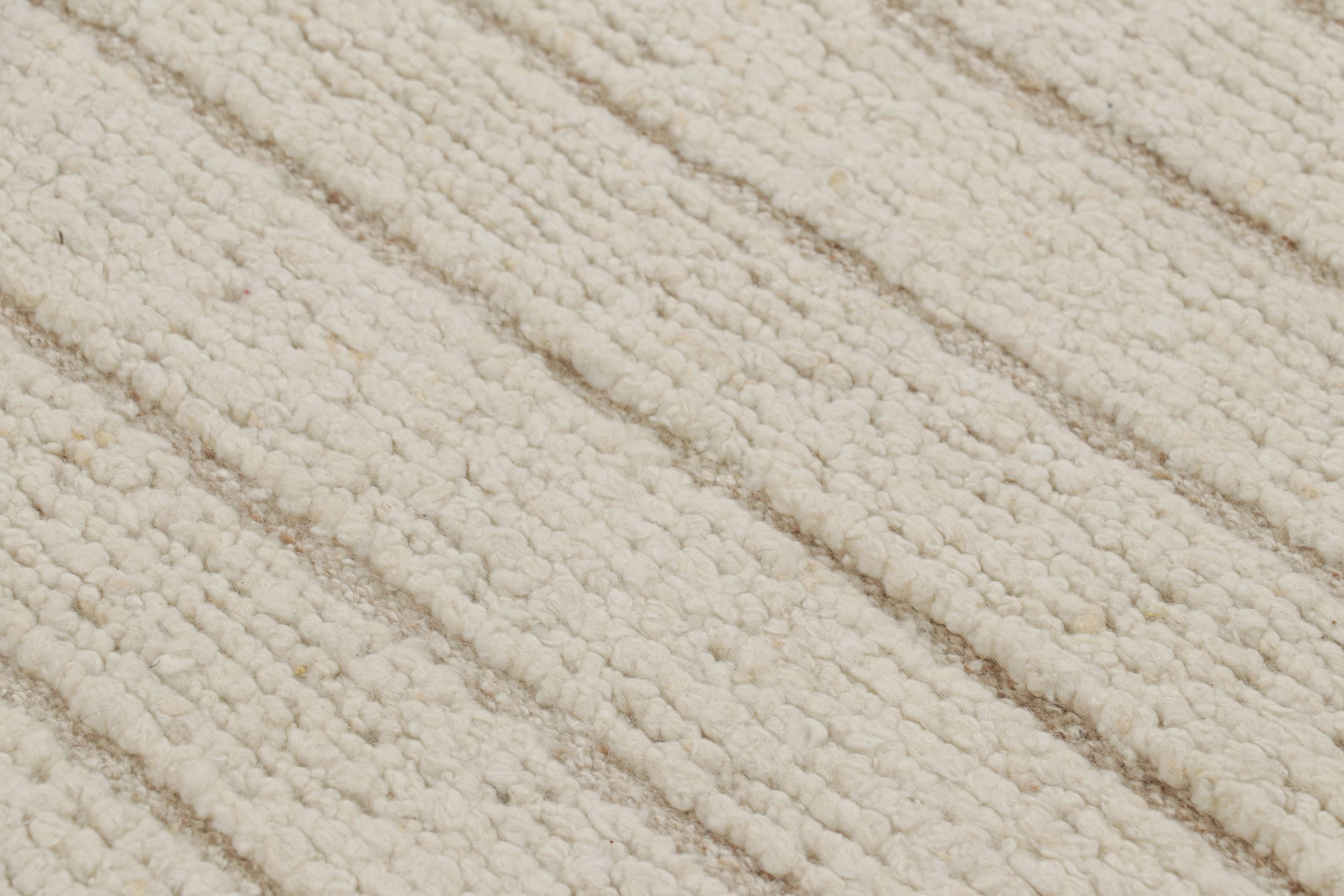 Hand-knotted in wool, this 8x10 modern rug features variations in color and a Moroccan-like texture and a simple series of stripes with the most tasteful high-and-low texture married to them—a look both comfortable and dimensional. 

On the Design: