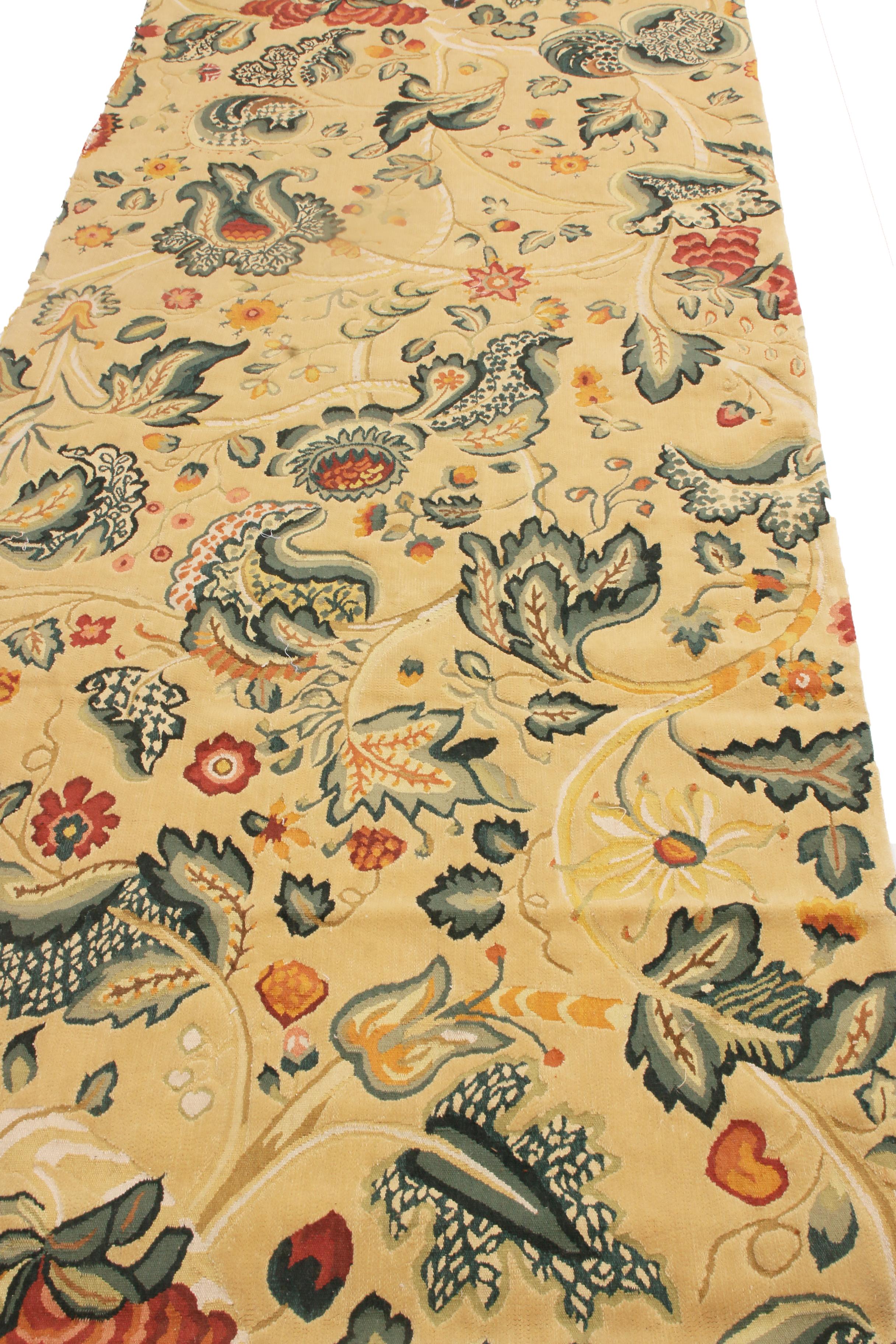 Originaria de China, esta alfombra floral anudada a mano se inspira en los diseños de las antiguas alfombras florales Tudor del siglo XVIII, y presenta un diseño sin bordes con guirnaldas curvilíneas de flores verdes, rojas y amarillo dorado sobre