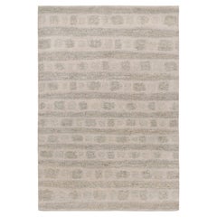 Rug & Kilim è un tappeto astratto con motivi geometrici grigi e beige.
