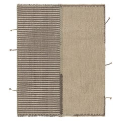 Rug & Kilim è un tappeto quadrato a strisce color crema e grigio.