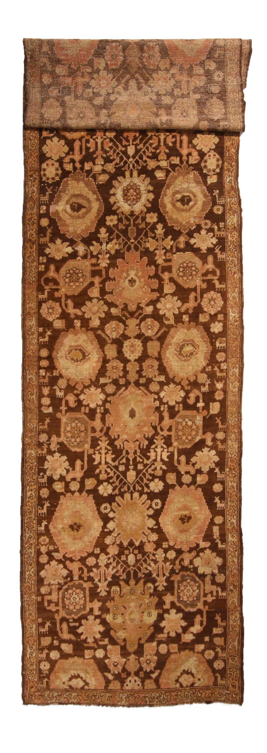 Originating from Russia in 1910, this antique Karabagh runner hosts an uncommonly fine single border, emphasizing a spacious, complementary geometric-floral series. Hand knotted in high quality, luminous wool, this textural, slightly abrash brown
