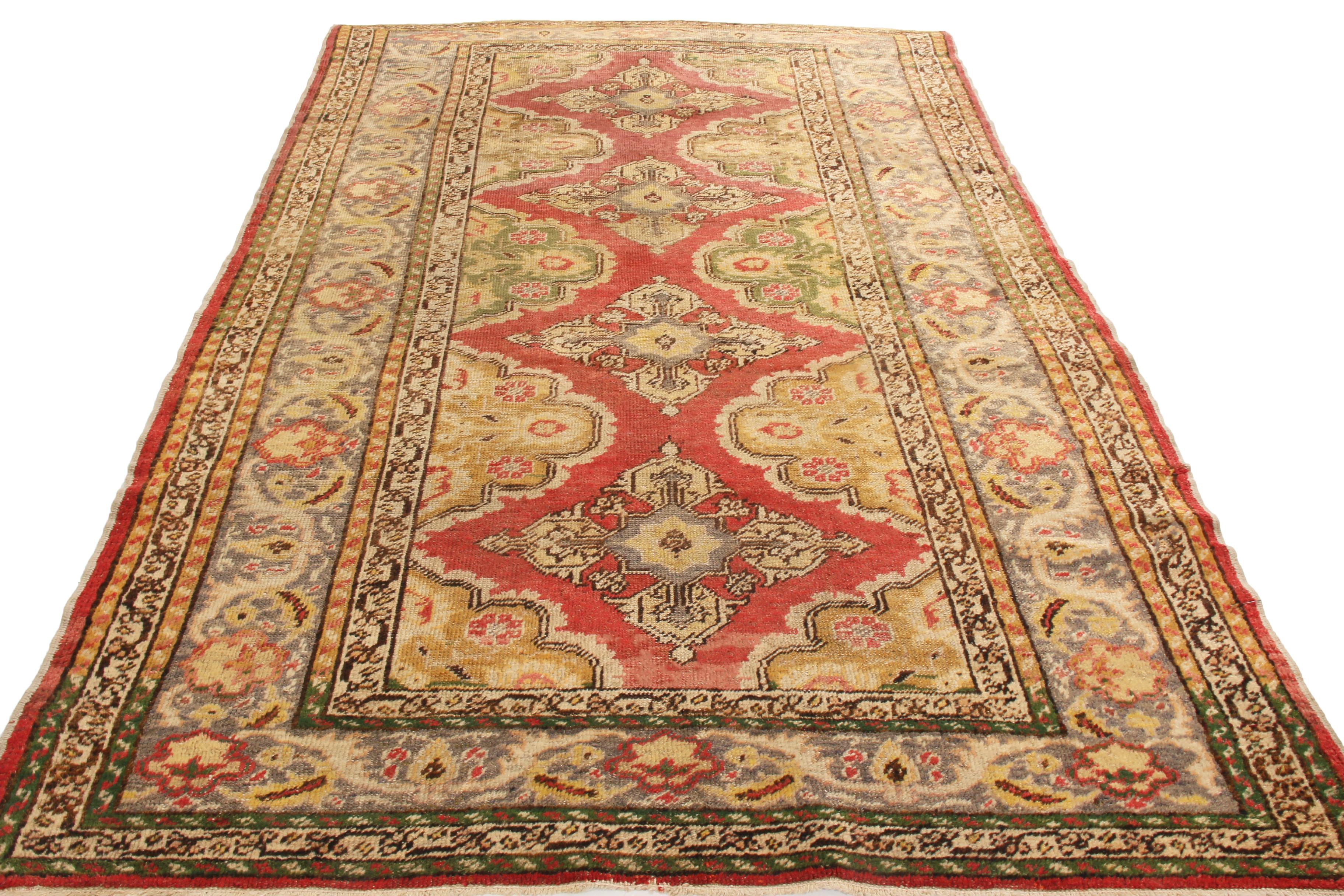 Originating from Turkey in 1910, this antique traditional Kayseri rug has a unique colorway orientation to complement its universal symmetry. Hand knotted in high-quality wool, the red background of the field elevates four repetitious but very