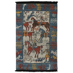 Rug & Kilim è un tappeto tribale caucasico di colore beige con immagini di guerrieri a cavallo