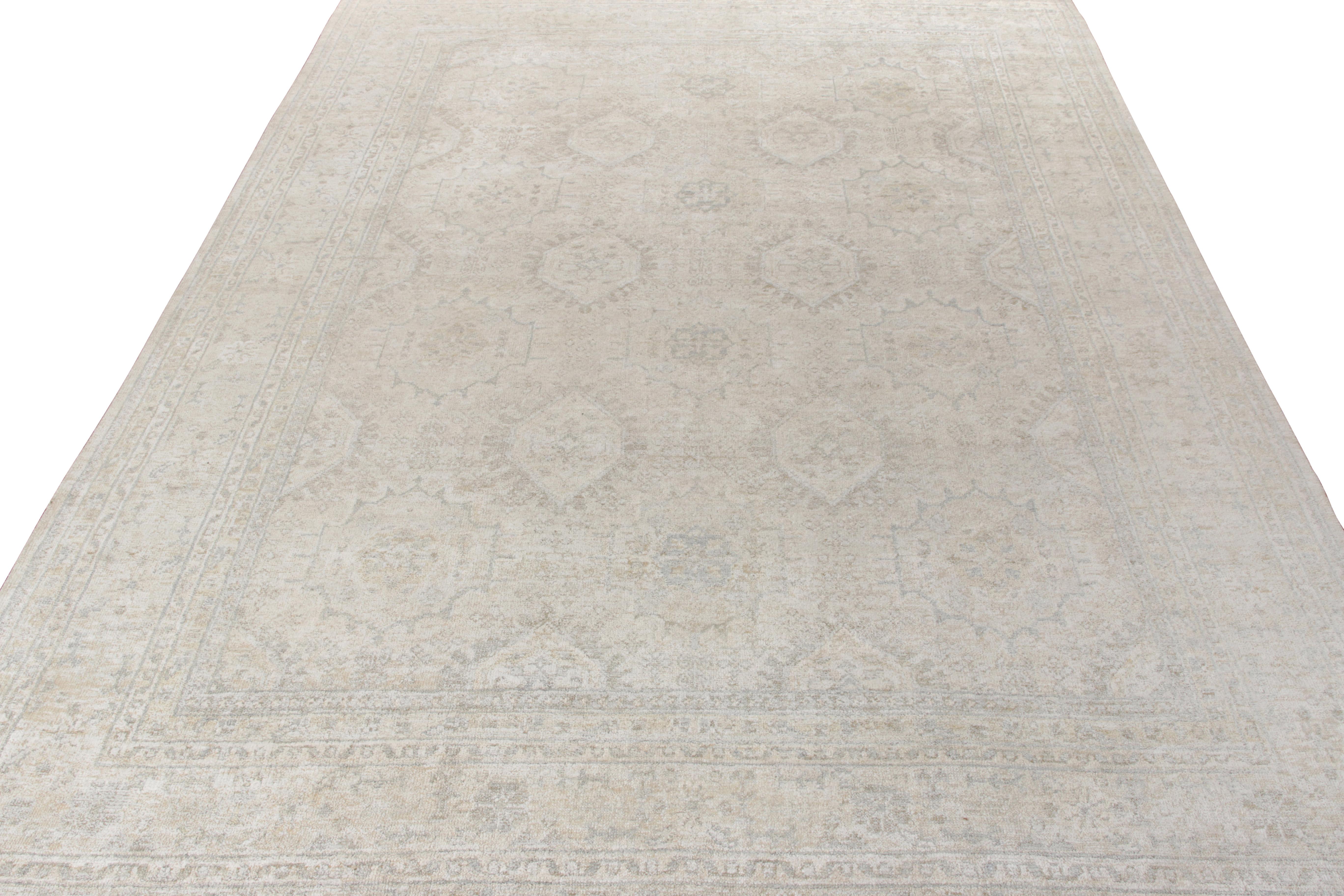 Hand knotted in wool & silk, an Indian style custom rug from Rug & Kilim’s Modern Classics collection. Exemplified in this 10x14 edition, the rug features an all over geometric-floral pattern in complementary tones of blue and beige-gray with a