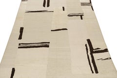 Rug & Kilim è un tappeto astratto contemporaneo di colore beige con motivi geometrici marroni.