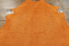 Rug & Kilim’s Contemporary Cowhide Solid Rug in Vibrant Orange Hues