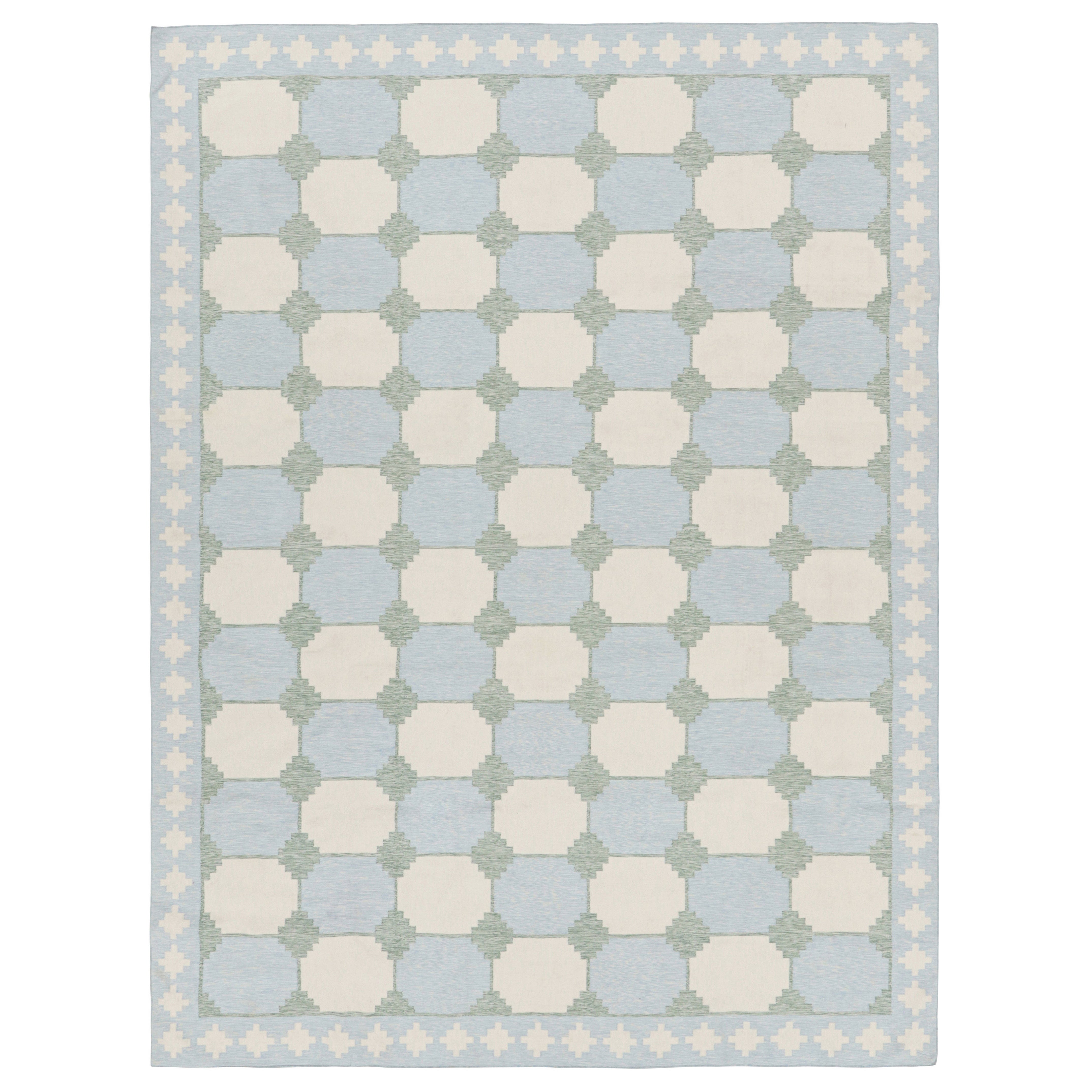Rug & Kilim è una dhurrie contemporanea in blu con motivi geometrici color crema e verde acqua.