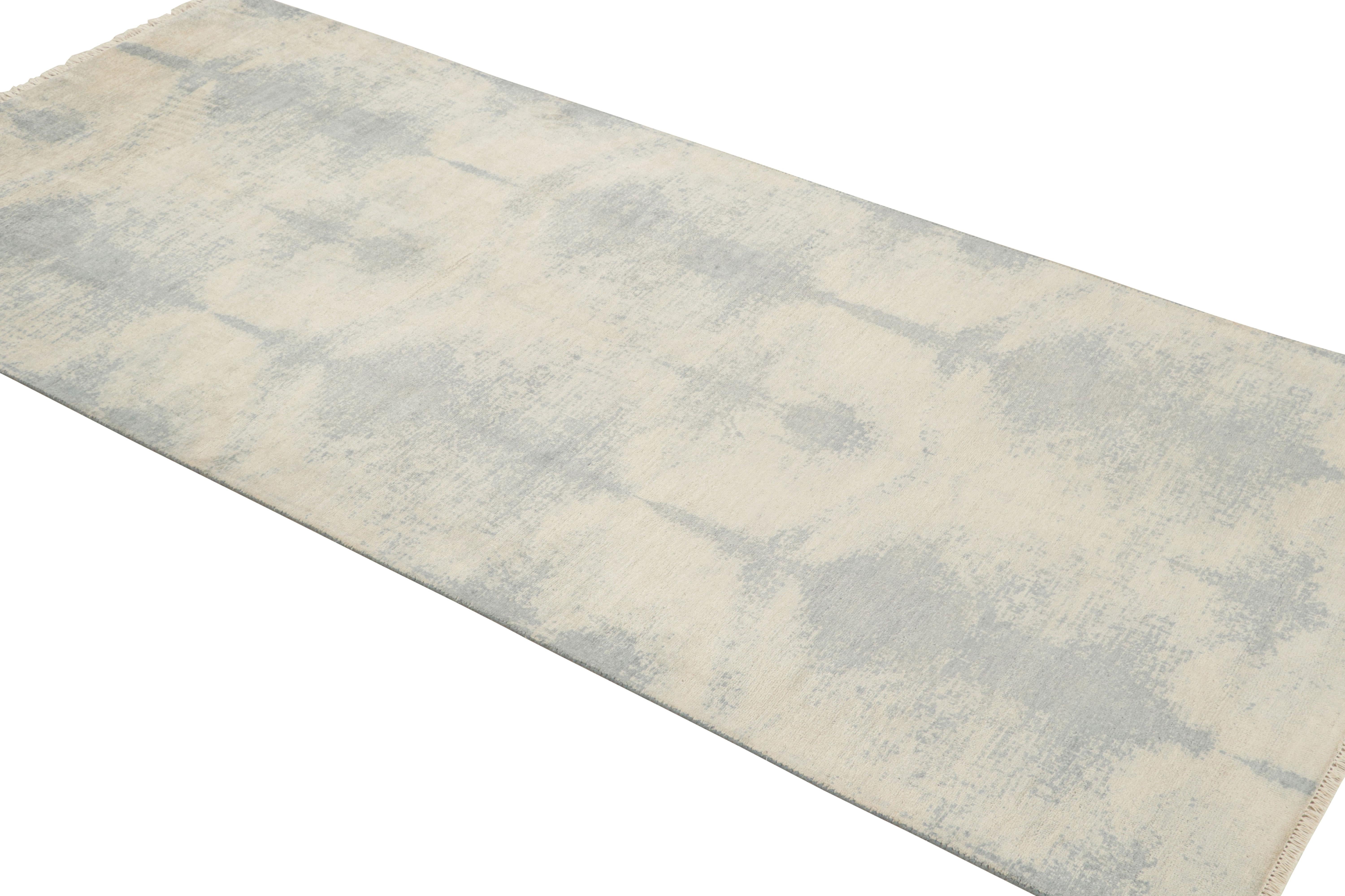 Hand knotted in 65 percent wool and 25 percent silk originating from India, this geometric runner enjoys a luminous, borderless geometric azure blue field design against a complementary ivory background, lending versatility and natural light under