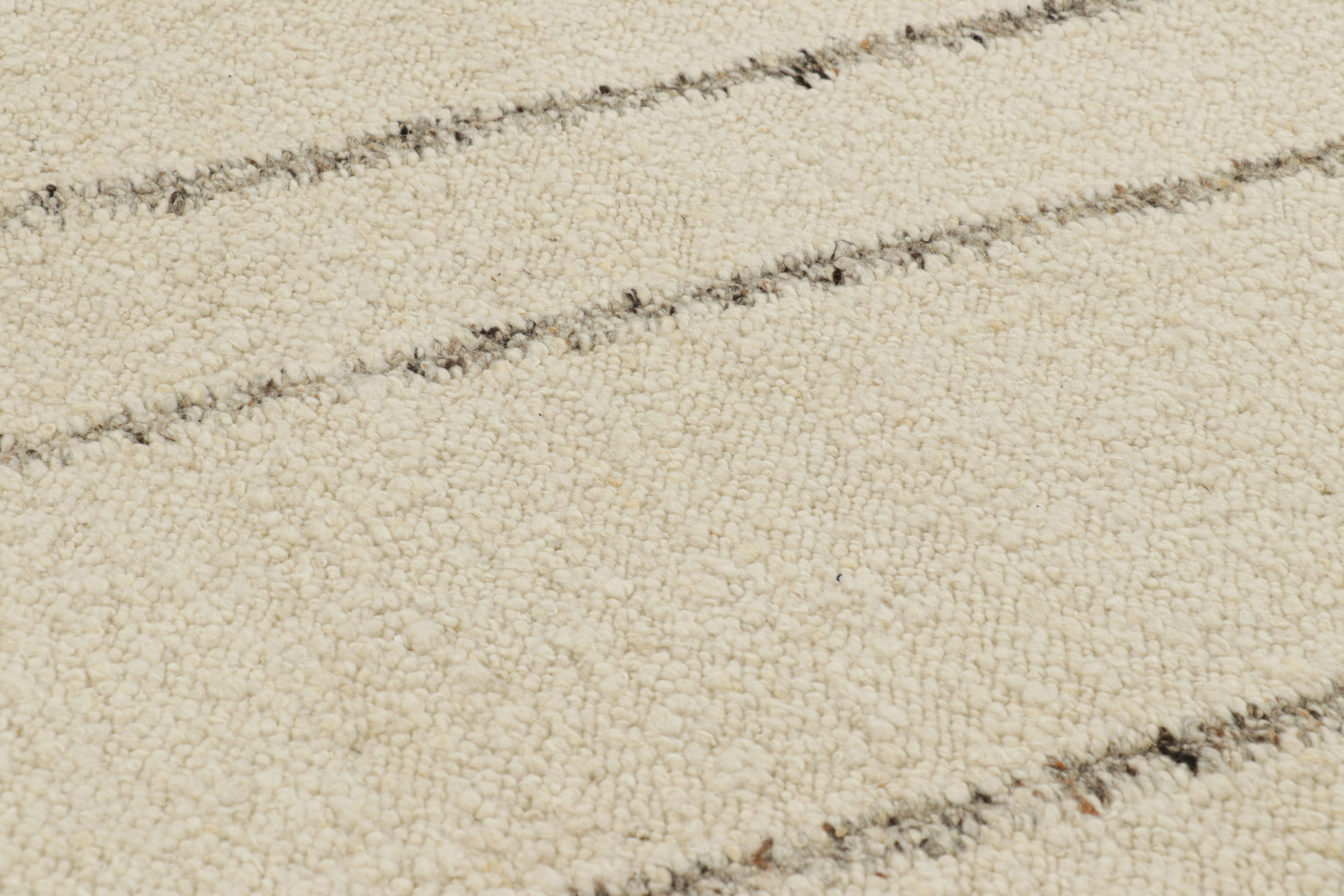 Handwoven in wool, this 9x12 Kilim is a smart contemporary and textural piece from Rug & Kilim, with subtle variations in color and a boucle-like texture which lend a fabulous sense of dimension to the simple stripes atop its creamy white field.