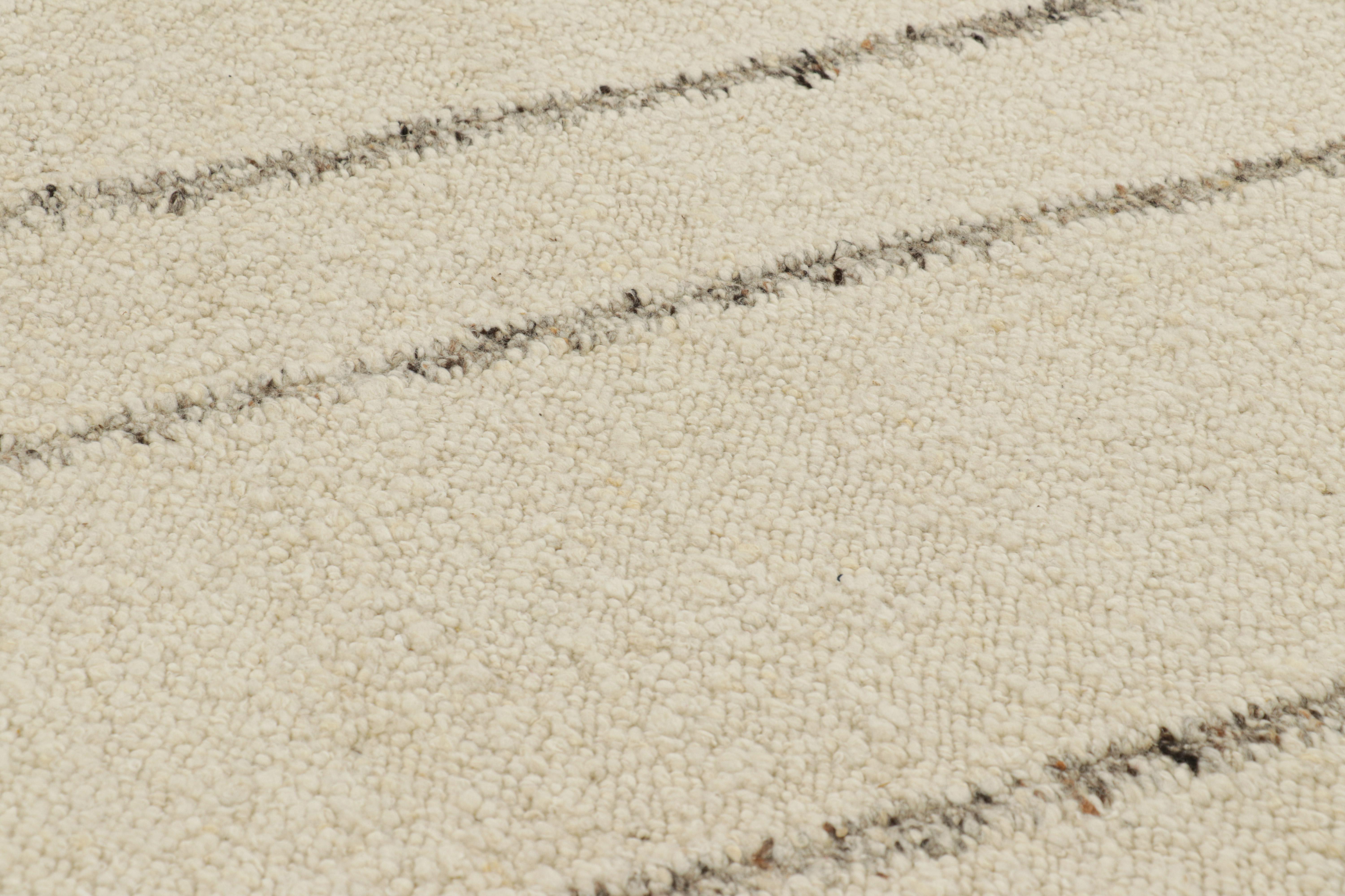 Dieser 9x12 Kilim aus handgewebter Wolle ist ein elegantes, modernes und strukturiertes Stück von Rug & Kilim, mit subtilen Farbvariationen und einer boucleartigen Textur, die den einfachen Streifen auf dem cremeweißen Feld ein fabelhaftes Gefühl