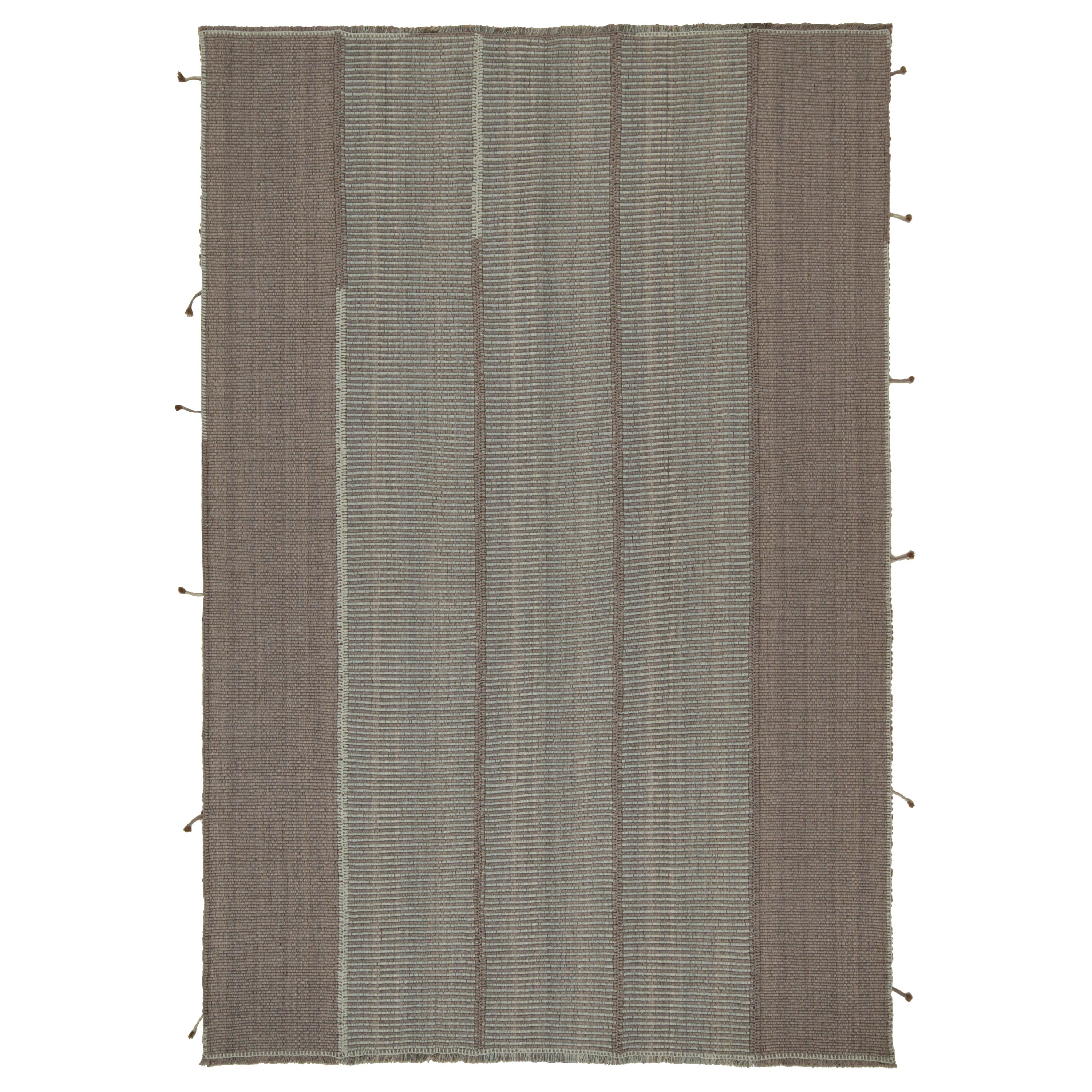 Rug & Kilim è un kilim contemporaneo a strisce grigie e blu con accenti marroni.