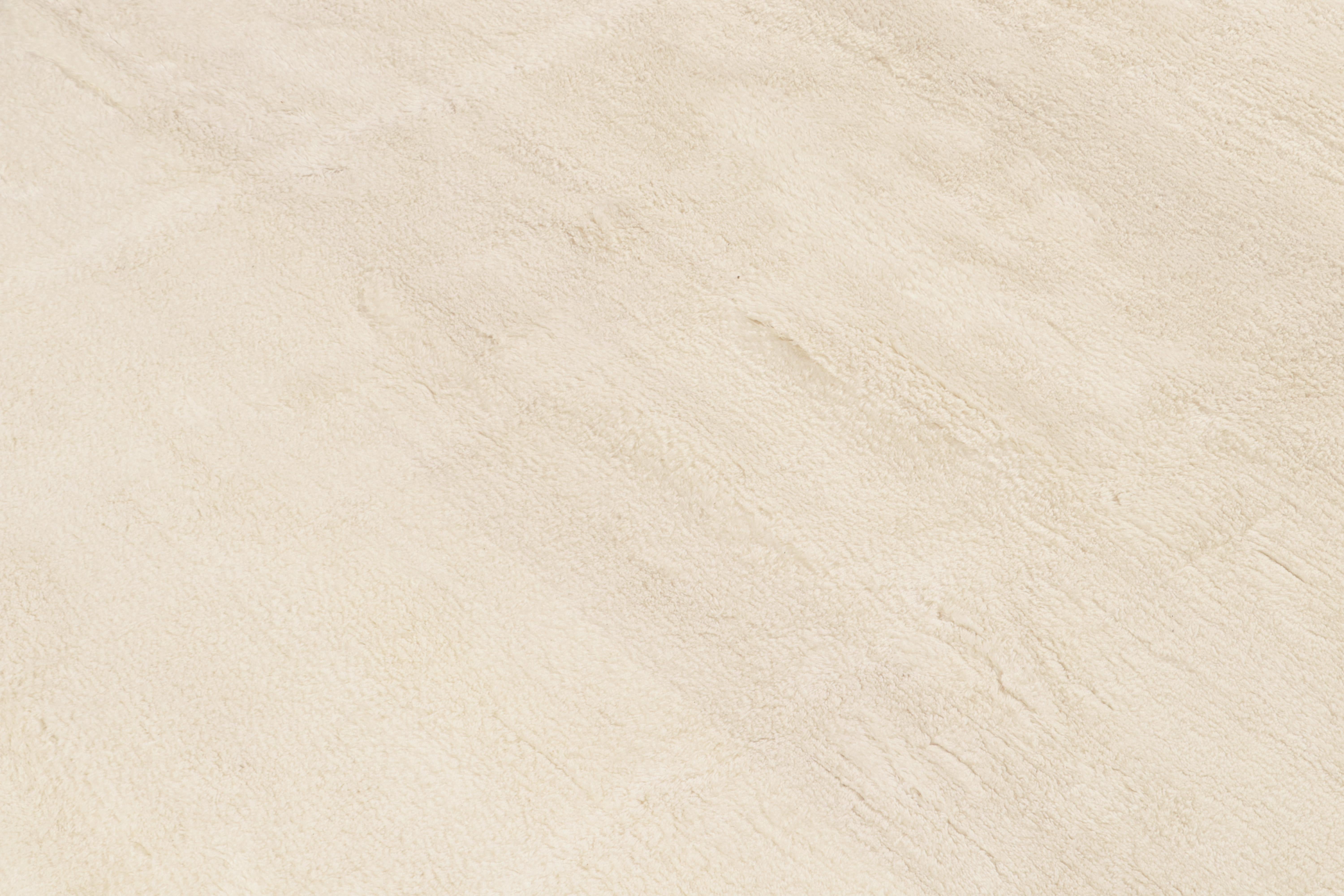 This contemporary 12x17 solid rug is a new addition to Rug & Kilim's Texture of Color Collection. Hand-knotted in all-natural wool.

Further on the Design:

This delicious blend of luxurious ivory and off-white tones further enjoys a subtle sheen