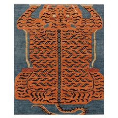 Rug & Kilim è un tappeto tigrato contemporaneo in blu con immagini in nero e arancione.