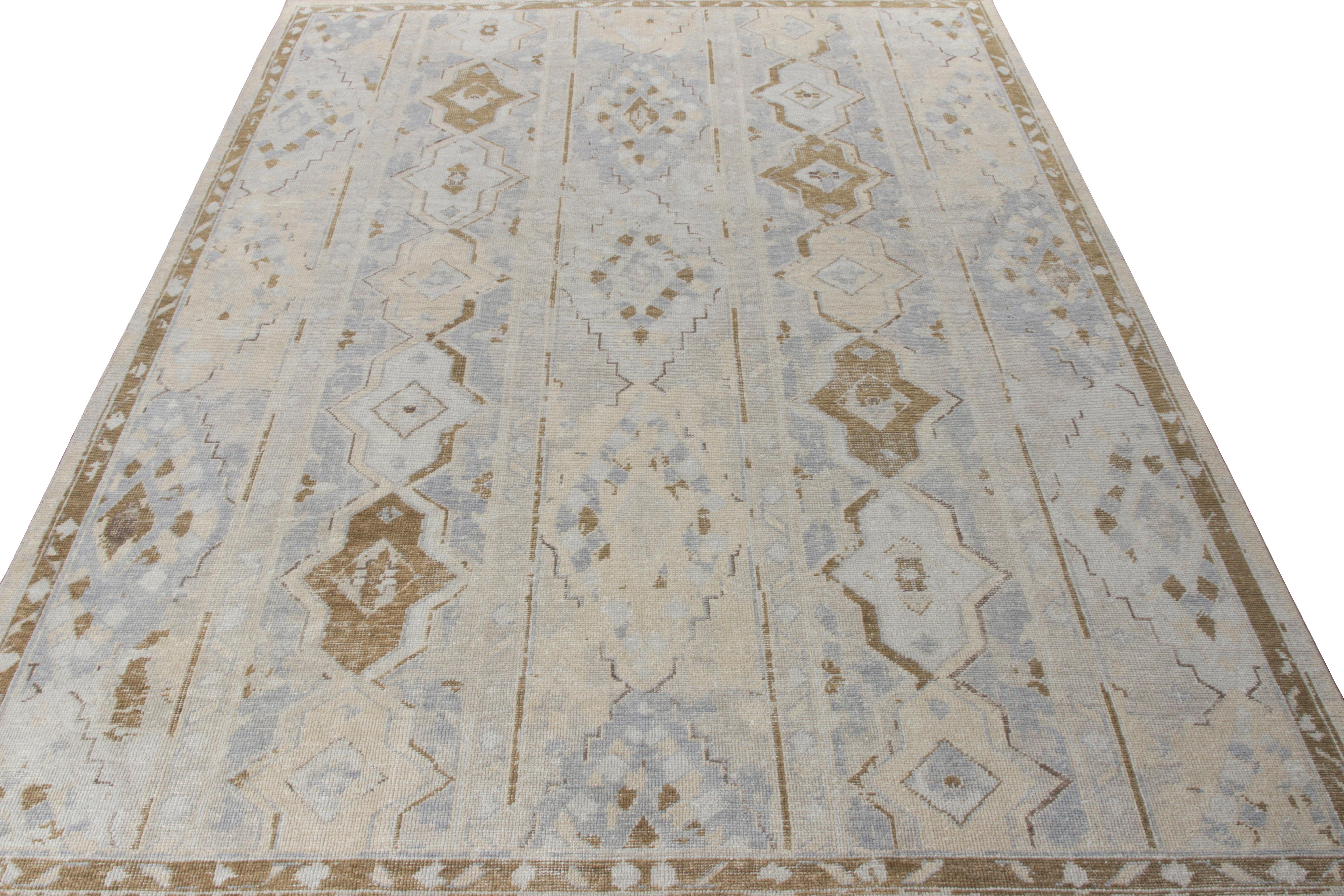 Ein 9x12 großer, handgeknüpfter Wollteppich aus der Homage Collection von Rug & Kilim. Diese Kreation zeichnet sich durch ein geschmackvolles geometrisches Muster in kühlen Blautönen und gemütlichen Beige-Brauntönen aus, das den charakteristischen