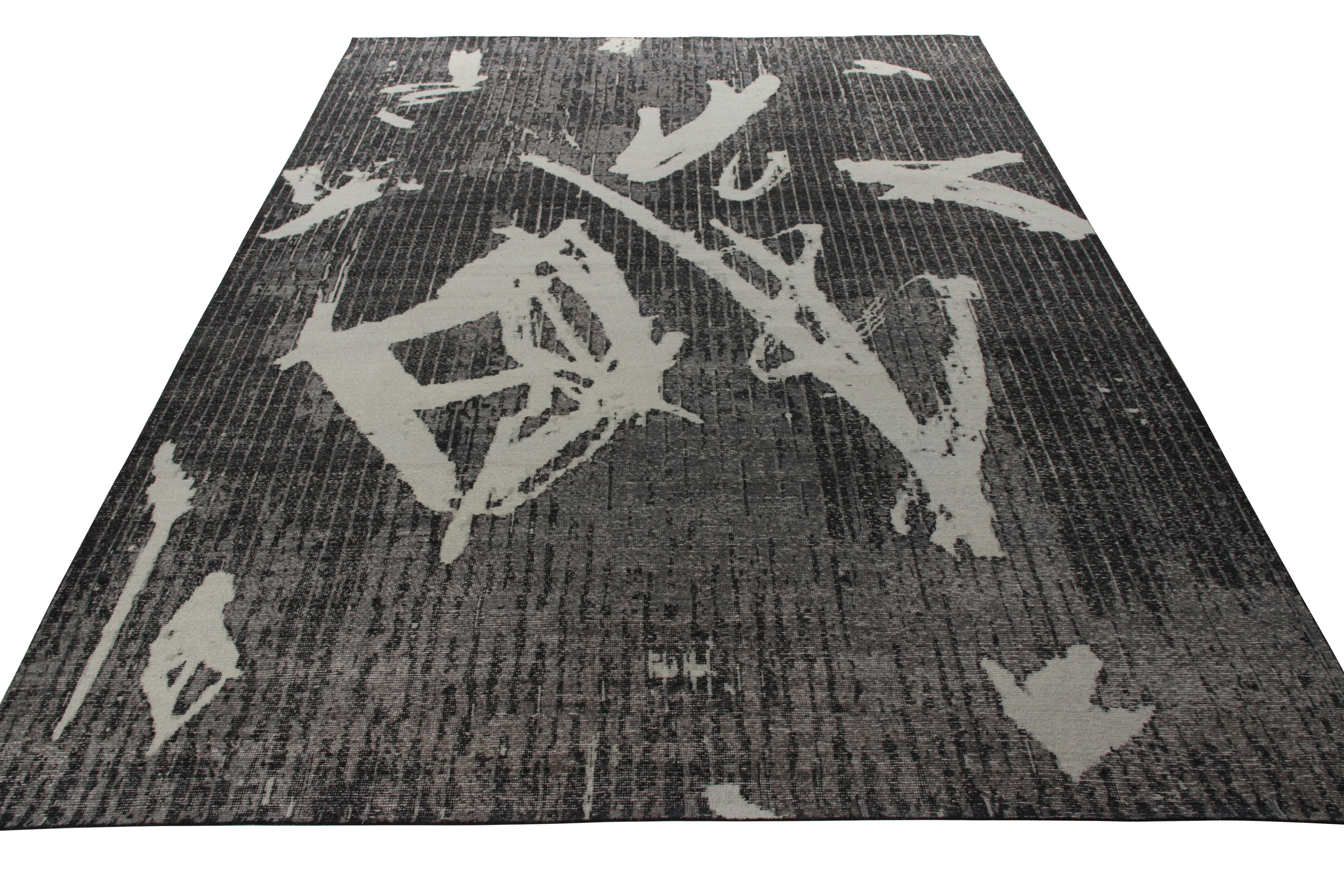 Ein handgeknüpfter Teppich im Format 10x14, der ein modernes, geometrisches Muster mit dem Stil des Distress verbindet und zur Homage Collection'S von Rug & Kilim gehört. Der Teppich ist im Shabby-Chic-Stil in hellen und dunklen Grautönen gehalten,