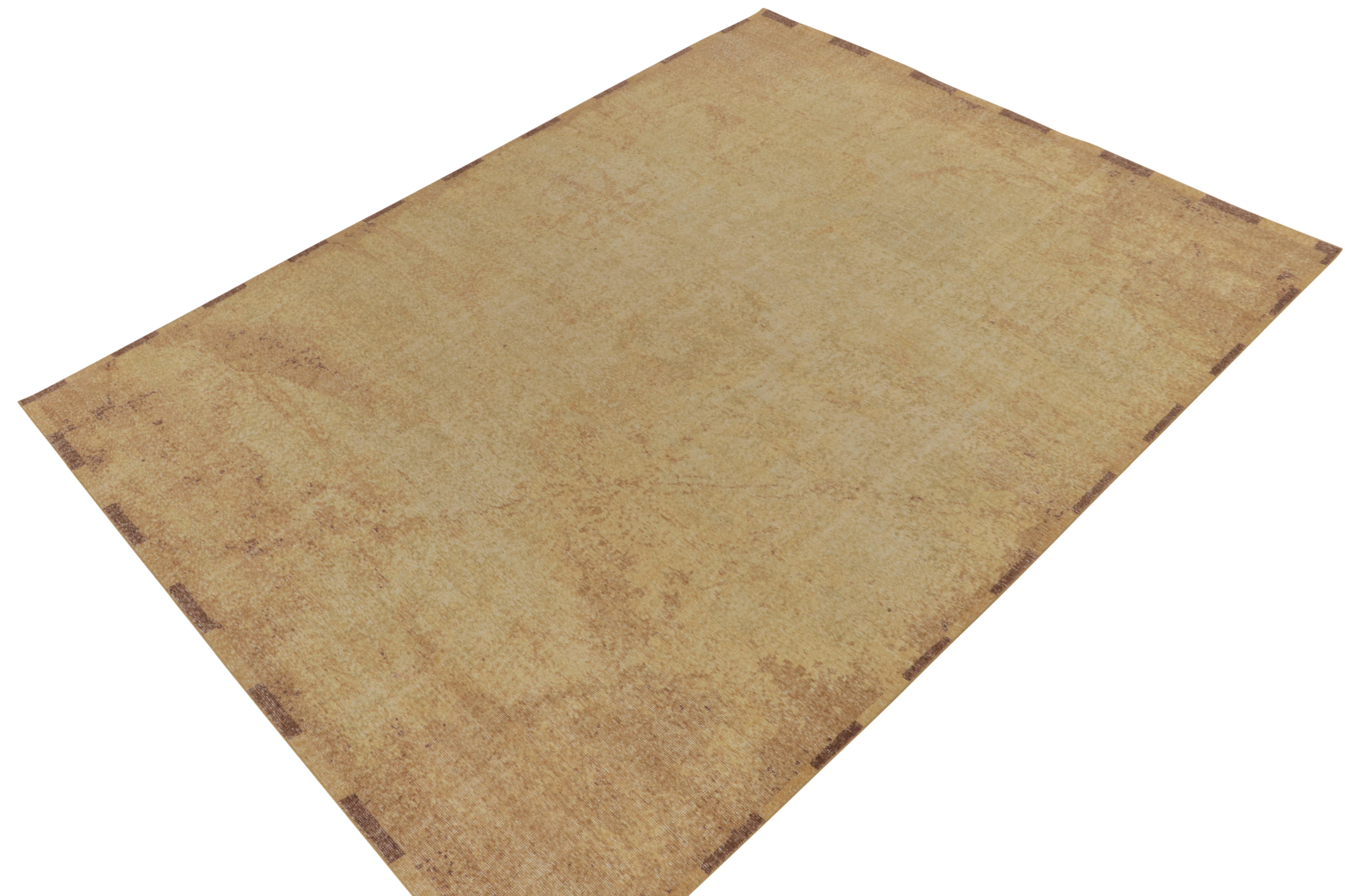 Issu de la collection Homage de Rug & Kilim, ce tapis abstrait 9x12 de style vieilli présente un jeu positif-négatif d'or et de brun somptueux qui donne une allure séduisante à cette célèbre ligne. Cette laine texturée à poils ras est un exemple de