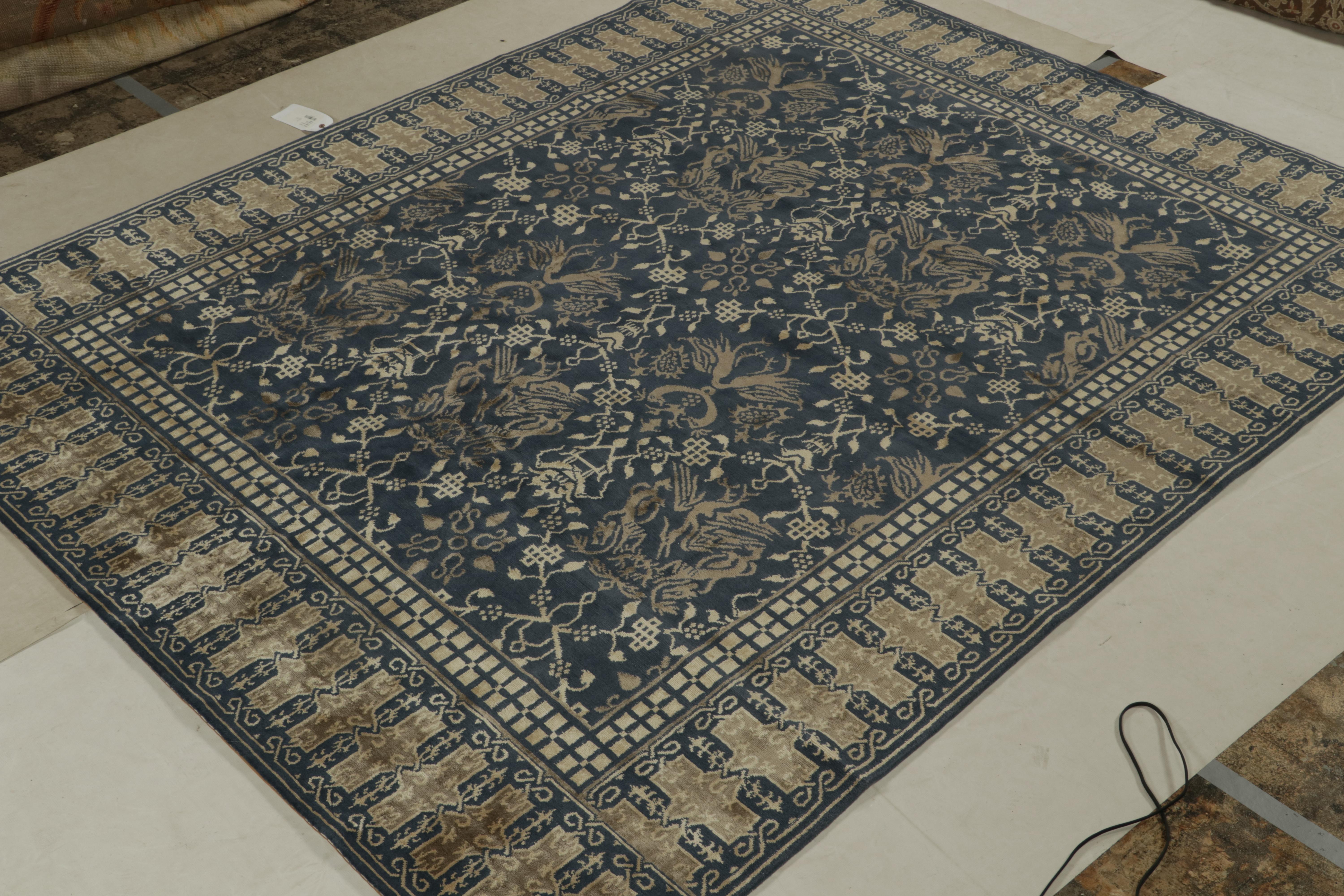 Questo tappeto 8x10 è una nuova aggiunta alla collezione europea di Rug & Kilim,  ispirato alle antiche interpretazioni dei tappeti orientali con draghi.  La sua miscela di lana e seta annodata a mano gioca con note di bronzo e beige sul blu